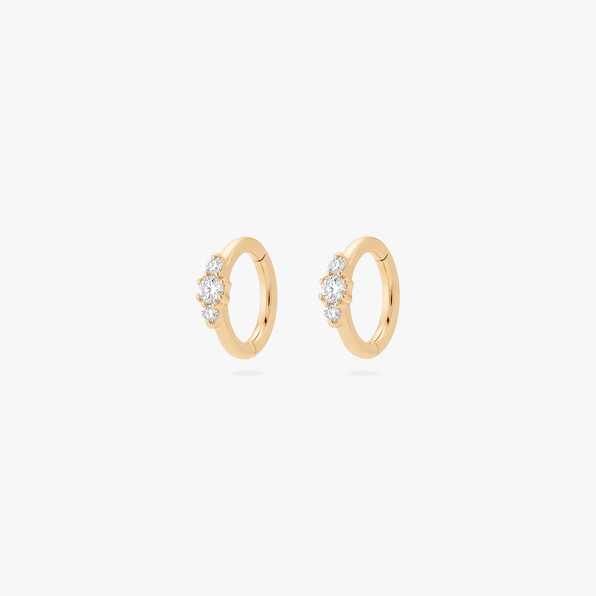 Pair of Gold clicker earrings with small cz stones on a white background