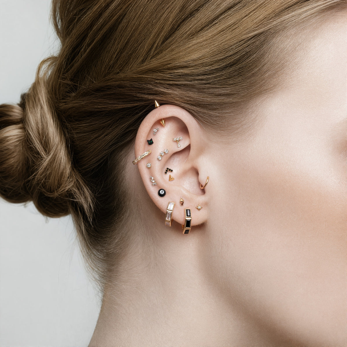 this image shows an earscape featuring the 14k gold plated max bezel baguette huggie with clear cz baguette stones. 