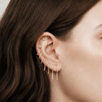 This image shows an earscape featuring the 14k gold plated long pave spike huggie with cz clear stones down the front 