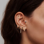 this image shows an earscape featuring the golden titanium 8 ball flatback with enamel. the outside of the ball is black and the inner circle is white 