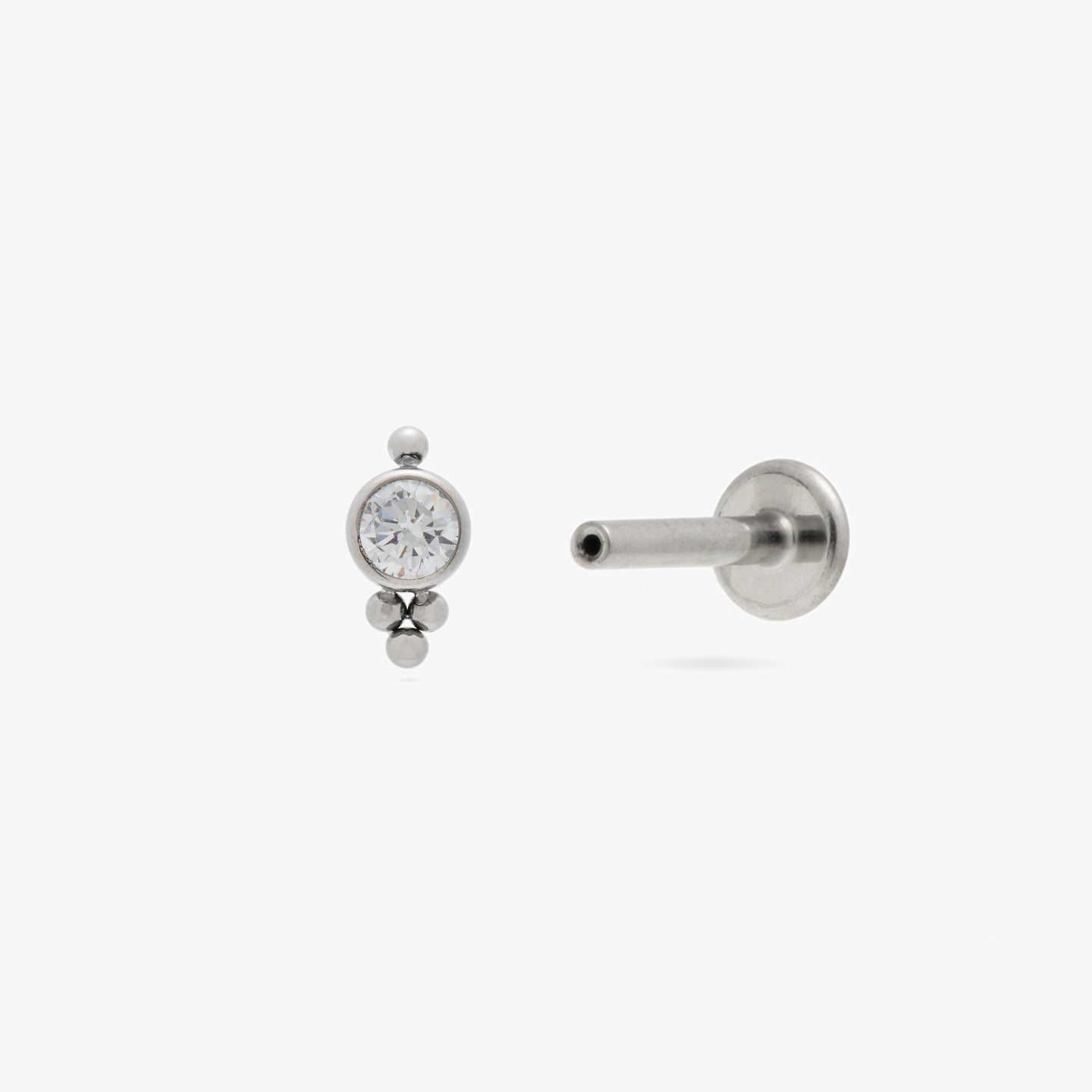 a triad shaped titanium stud with a CZ accent color:null|silver/clear