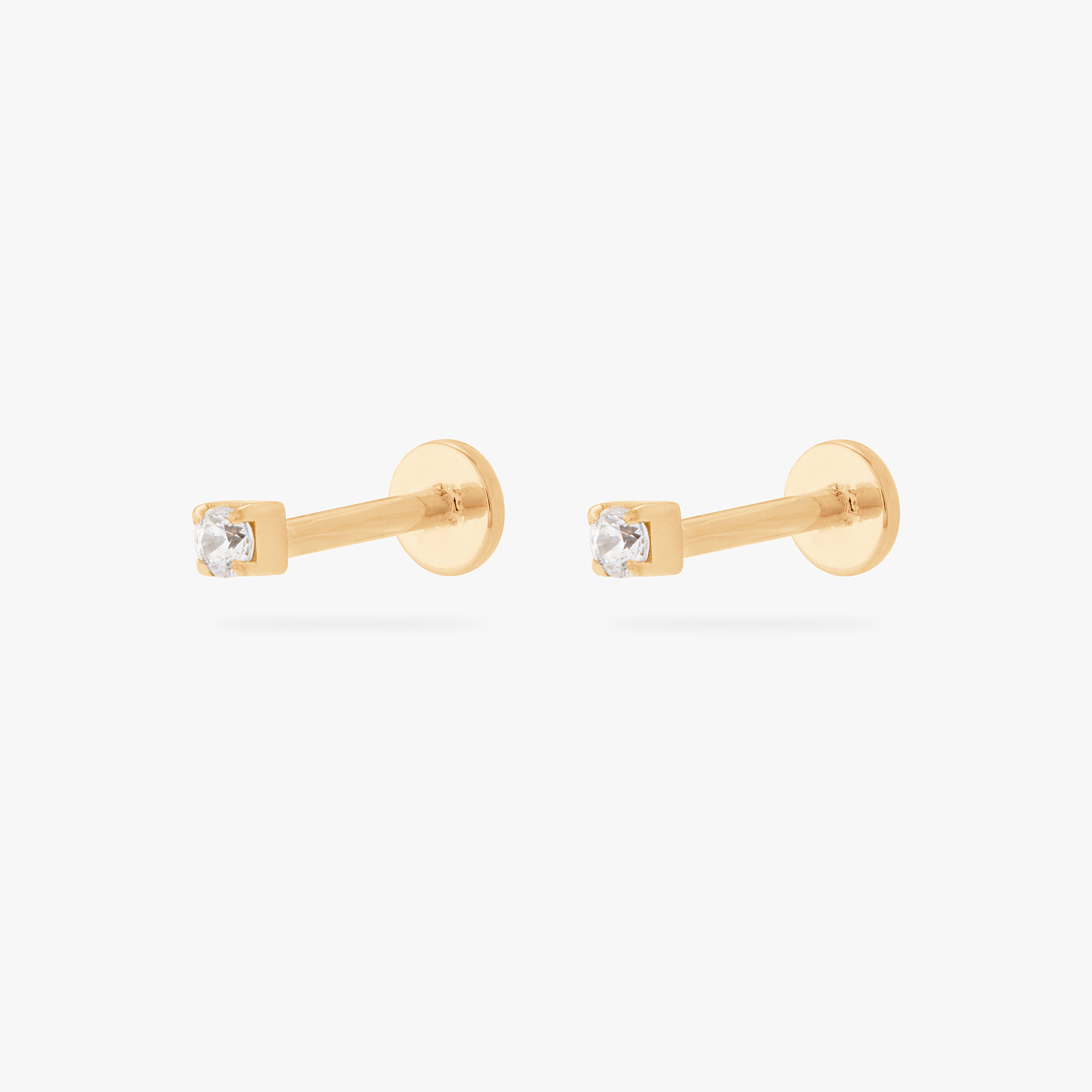 This is an image of a pair of gold/clear mini CZ flatback tops, with gold circle dics that are engraved with the "S" logo. [pair] color:null|gold/clear
