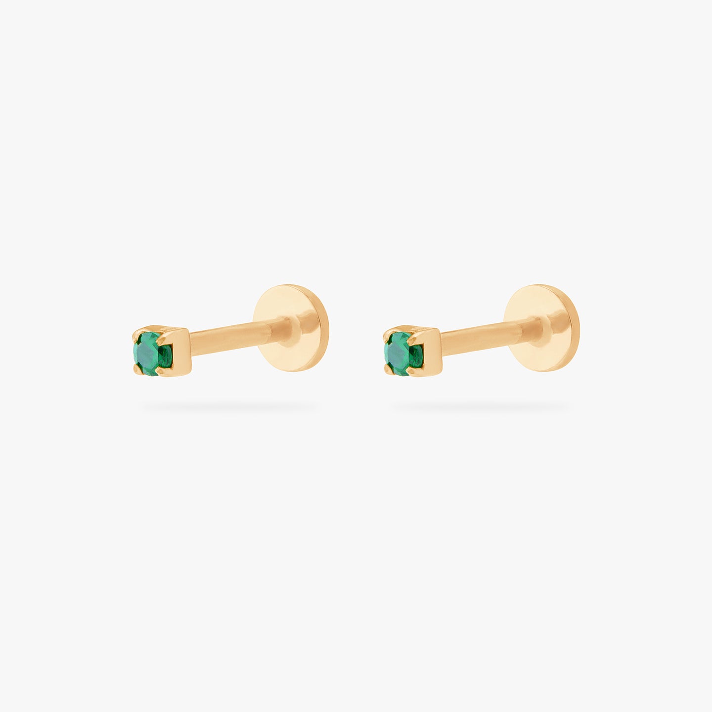 This is an image of a pair of gold/green mini CZ flatback tops, with gold circle dics that are engraved with the 