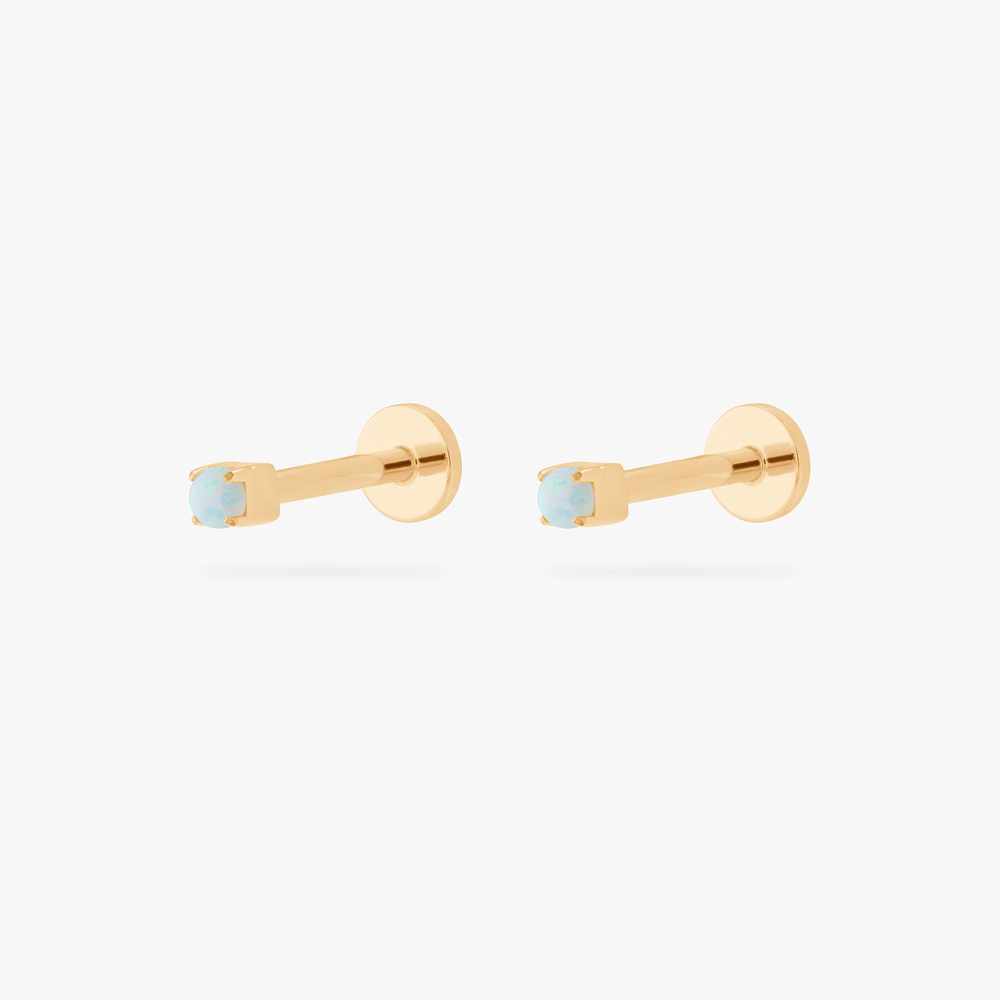 This is an image of a pair of gold/opal flatback tops with gold labrets with circle discs and the 