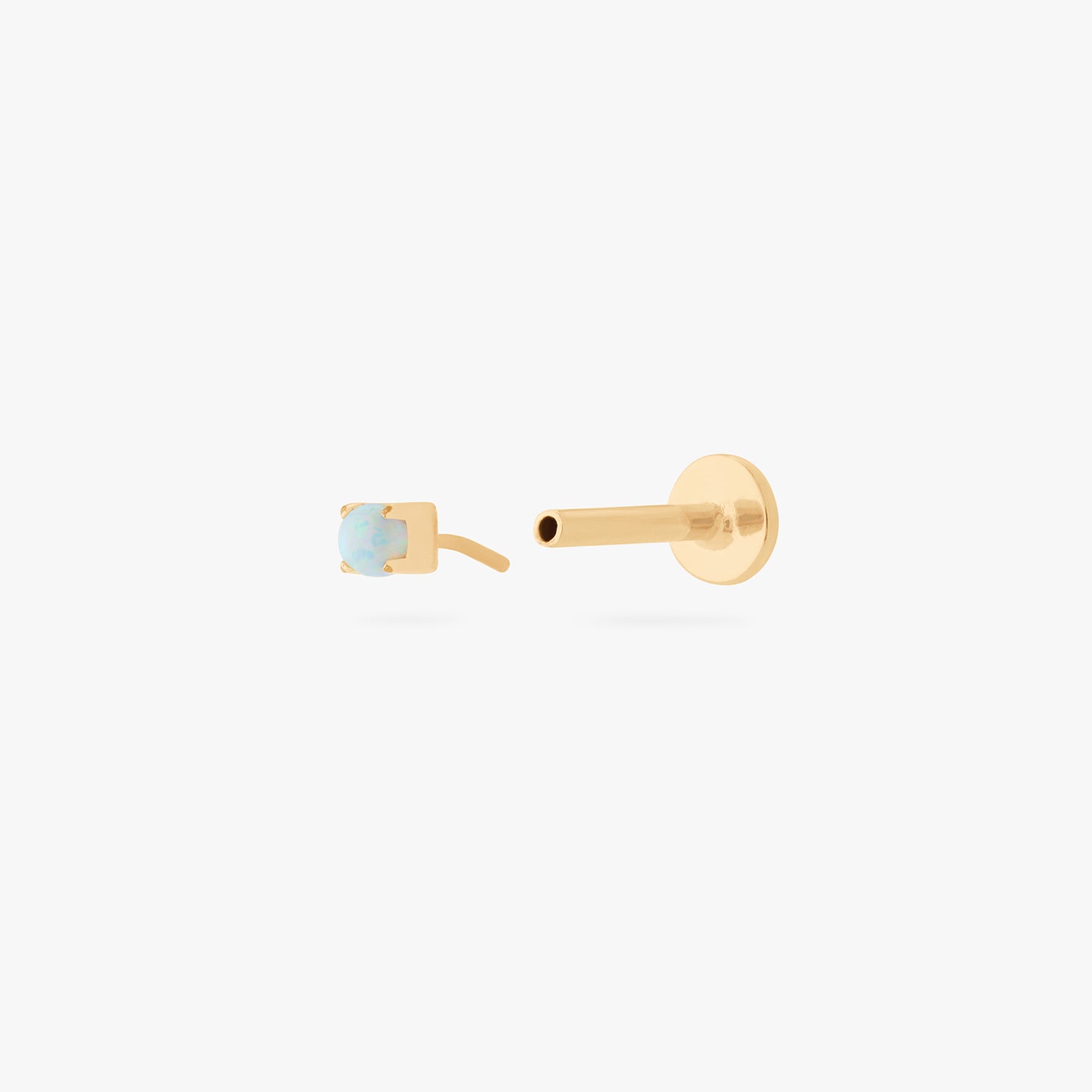 This is an image of a gold/opal flatback top with a gold labret with a circle disc and the 