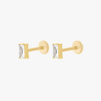 This is an image of a pair of gold toned flatback studs that display 5mm, clear baguette cut CZ stones.