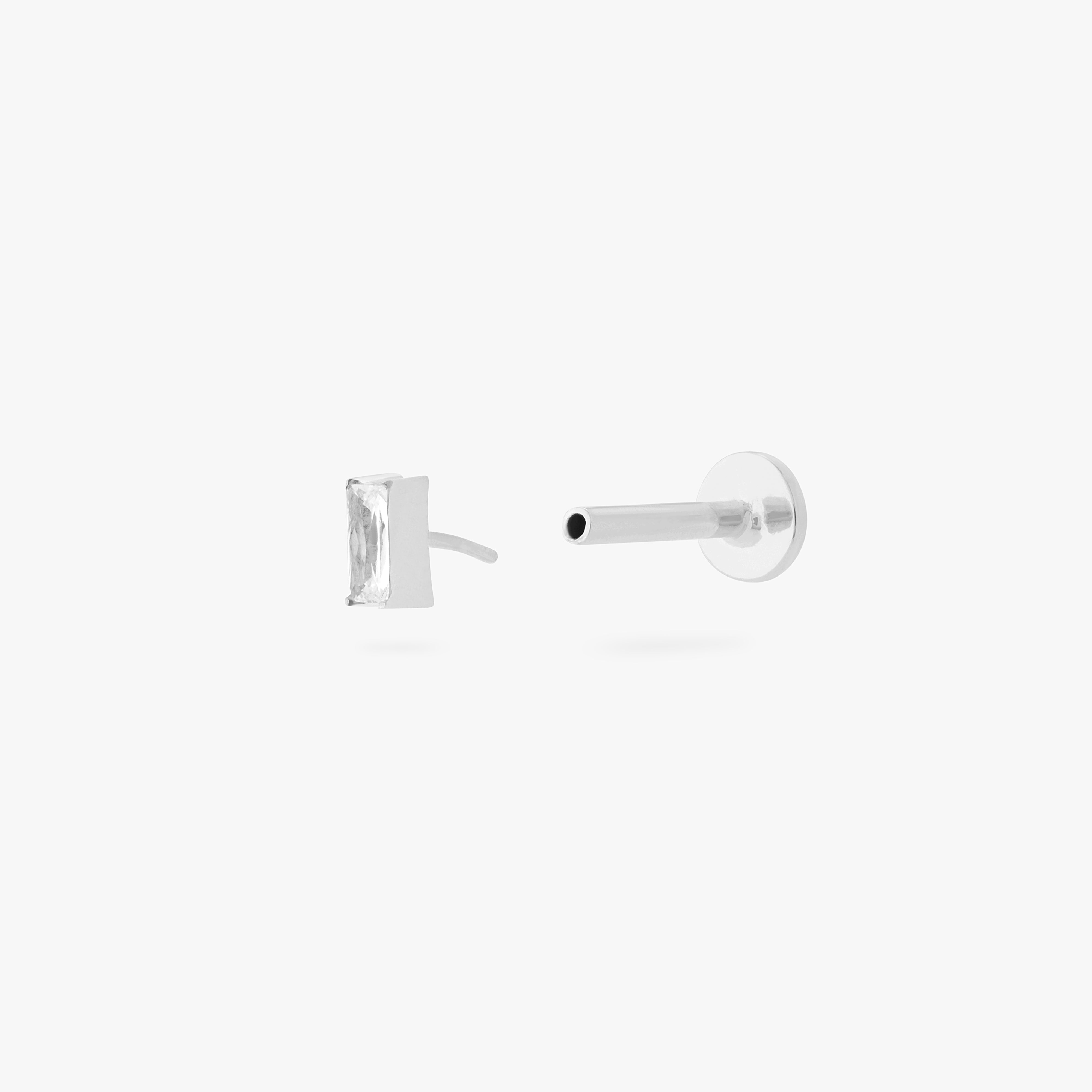 This is an image of a silver/clear baguette shaped CZ flatback stud, with a silver labret with a circle disc with an "S" logo engraved on it. color:null|silver/clear