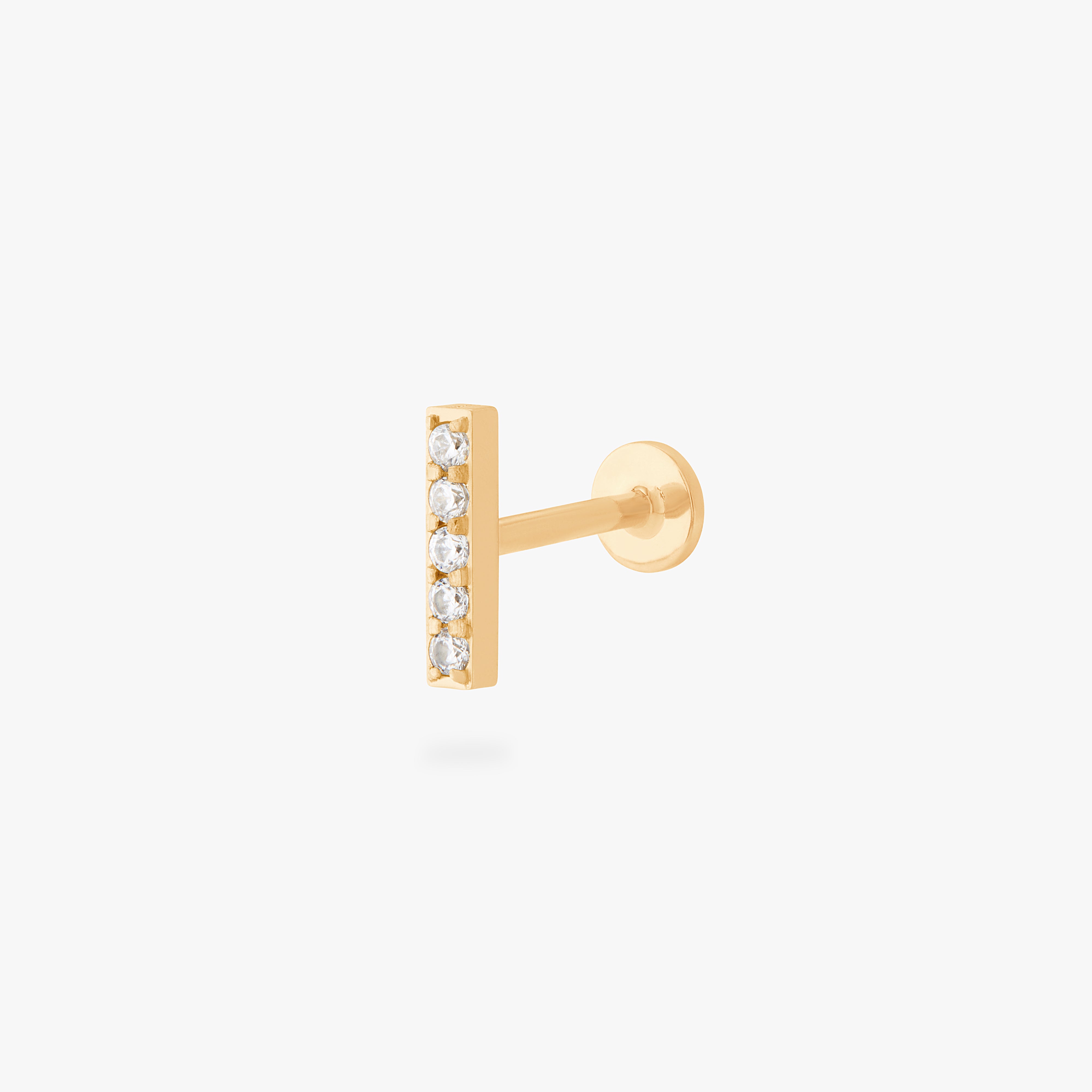 This is an image of a gold/clear bar that has 5 mini CZs in a line formation with a gold labret with a circle disc and the "S" logo engraved in it. color:null|gold/clear