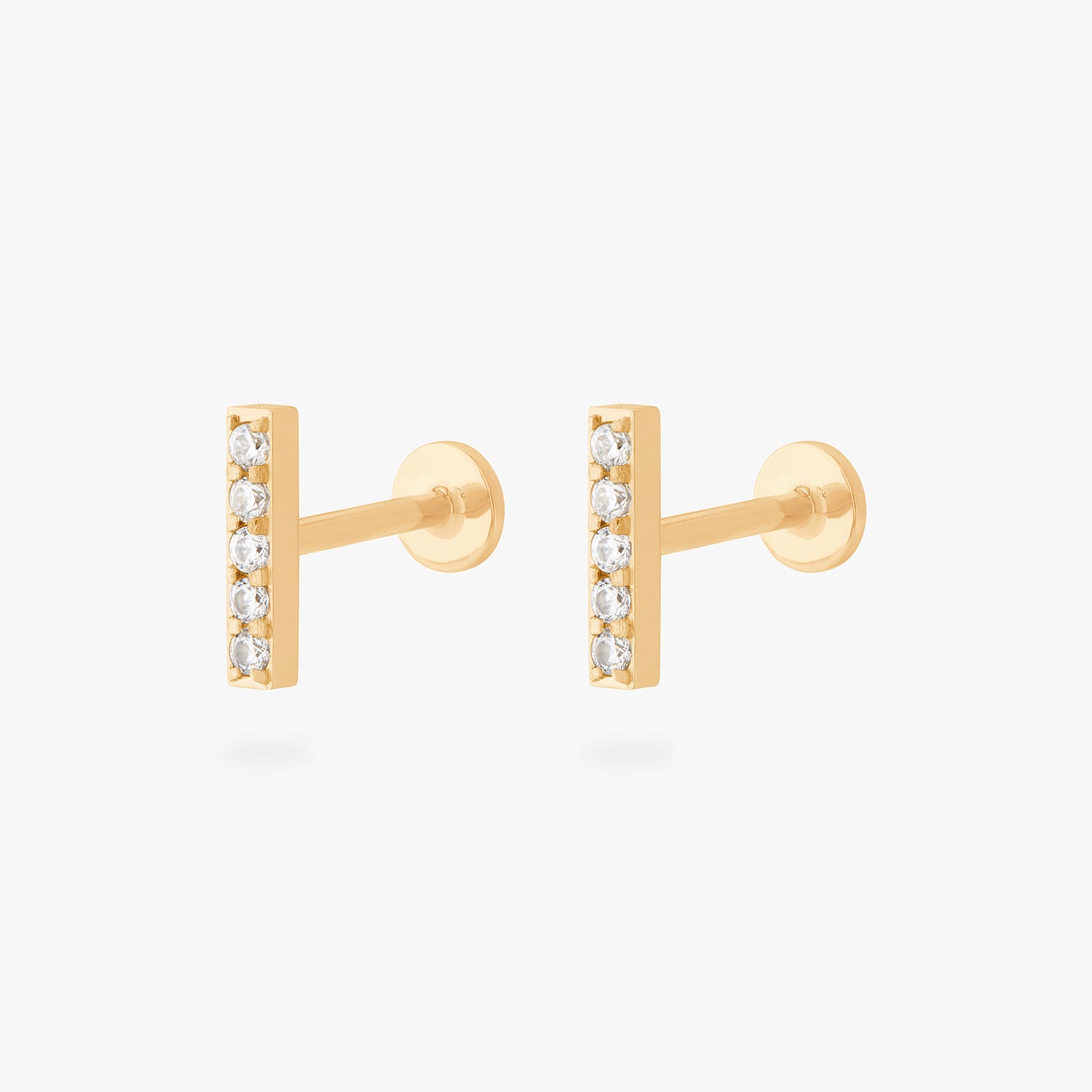 This is an image of a pair of gold/clear bars that have 5 mini CZs in a line formation with gold labrets with circle discs and the 