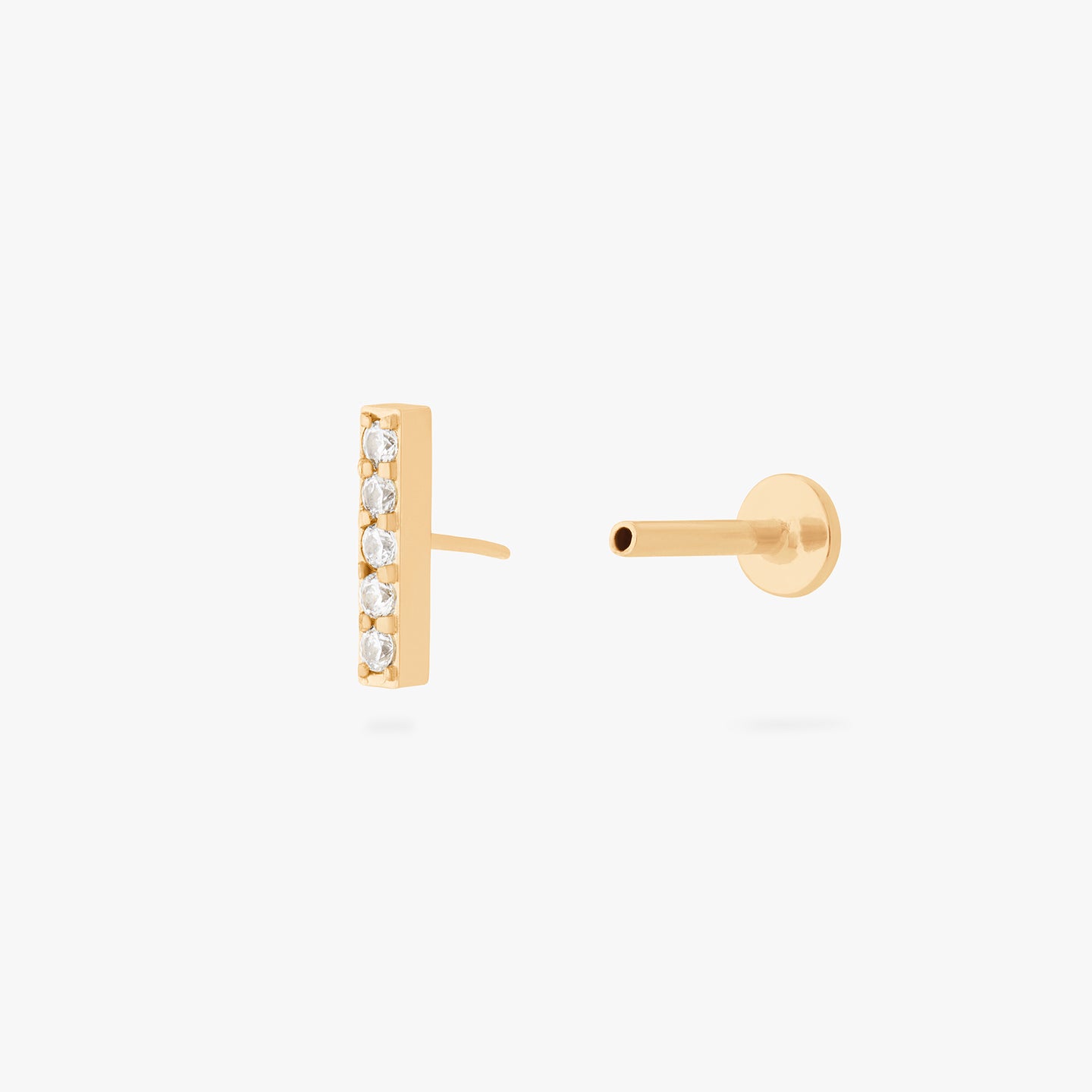 This is an image of a gold/clear bar that has 5 mini CZs in a line formation with a gold labret with a circle disc and the 