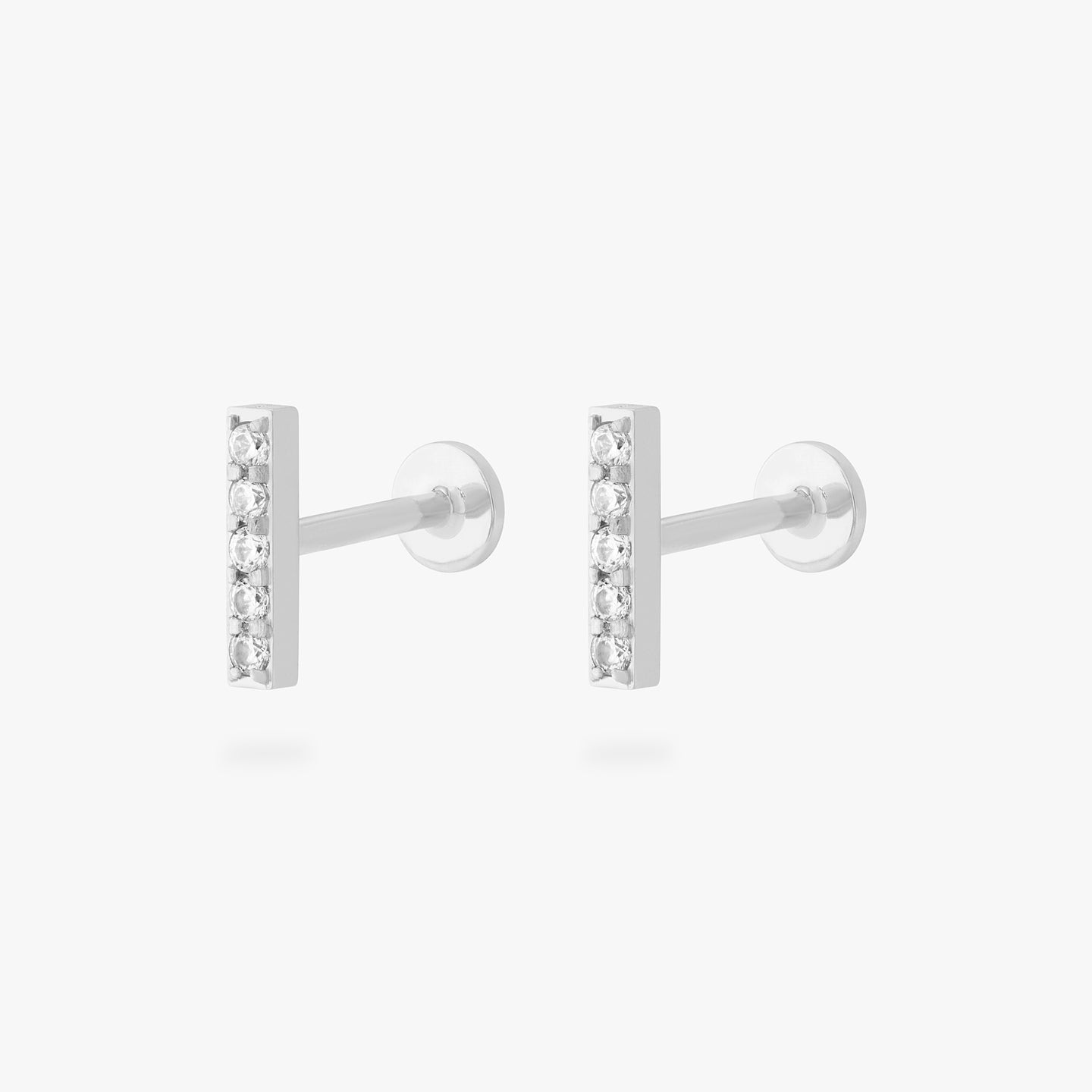 This is an image of a pair of silver/clear bars that have 5 mini CZs in a line formation with silver labrets with circle discs and the 