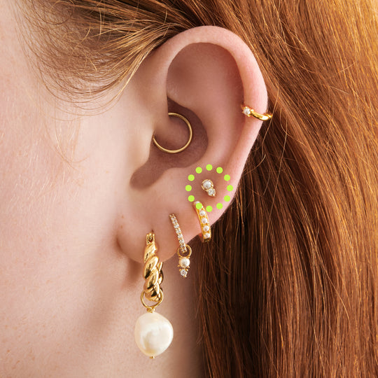 This is an image of a flatback top which has a pearl stacked over gold/clear CZ and then a gold labret that has a circle disc with the "S" logo engraved on it. [hover] color:null|gold/clear