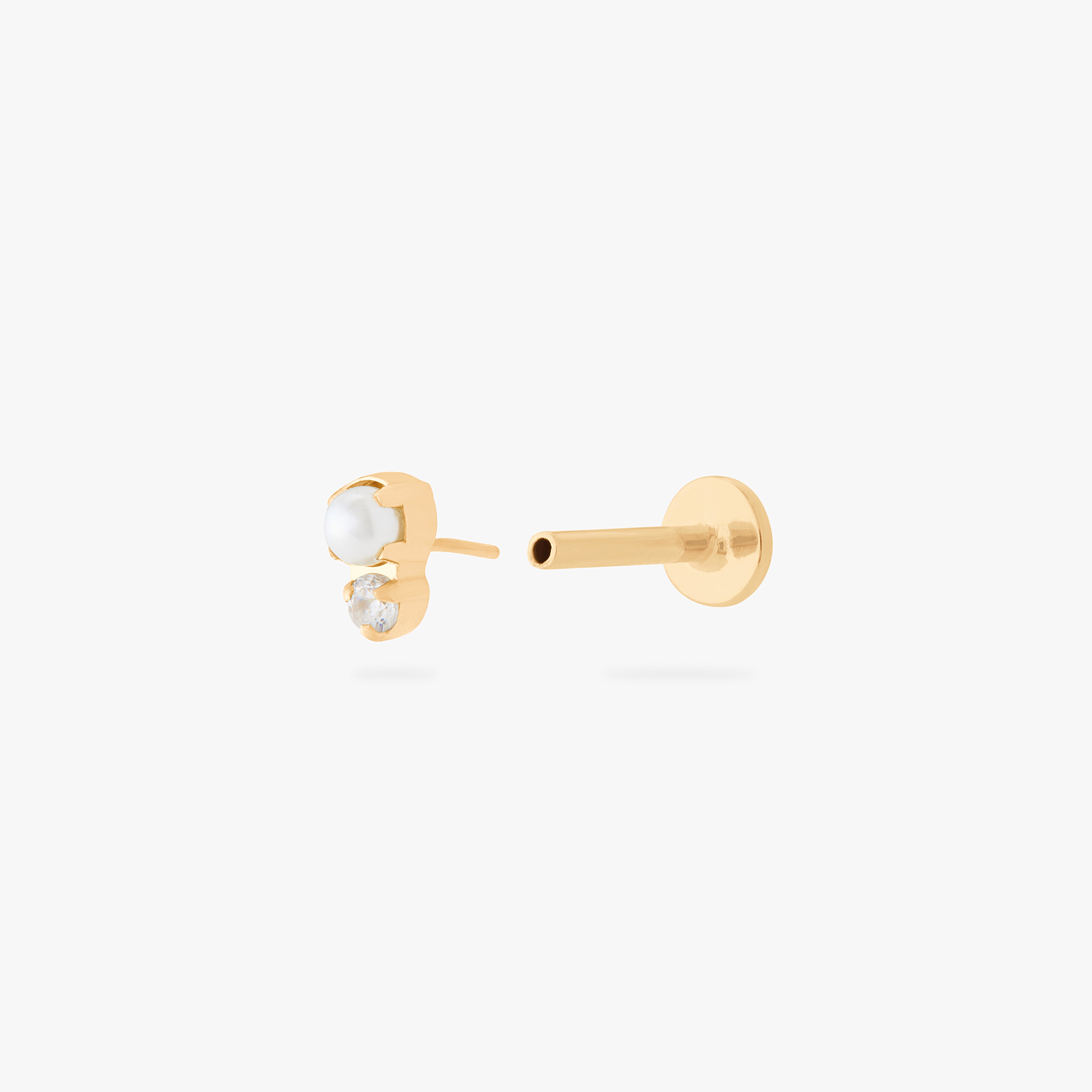 This is an image of a flatback top which has a pearl stacked over gold/clear CZ and then a gold labret that has a circle disc with the "S" logo engraved on it. color:null|gold/clear