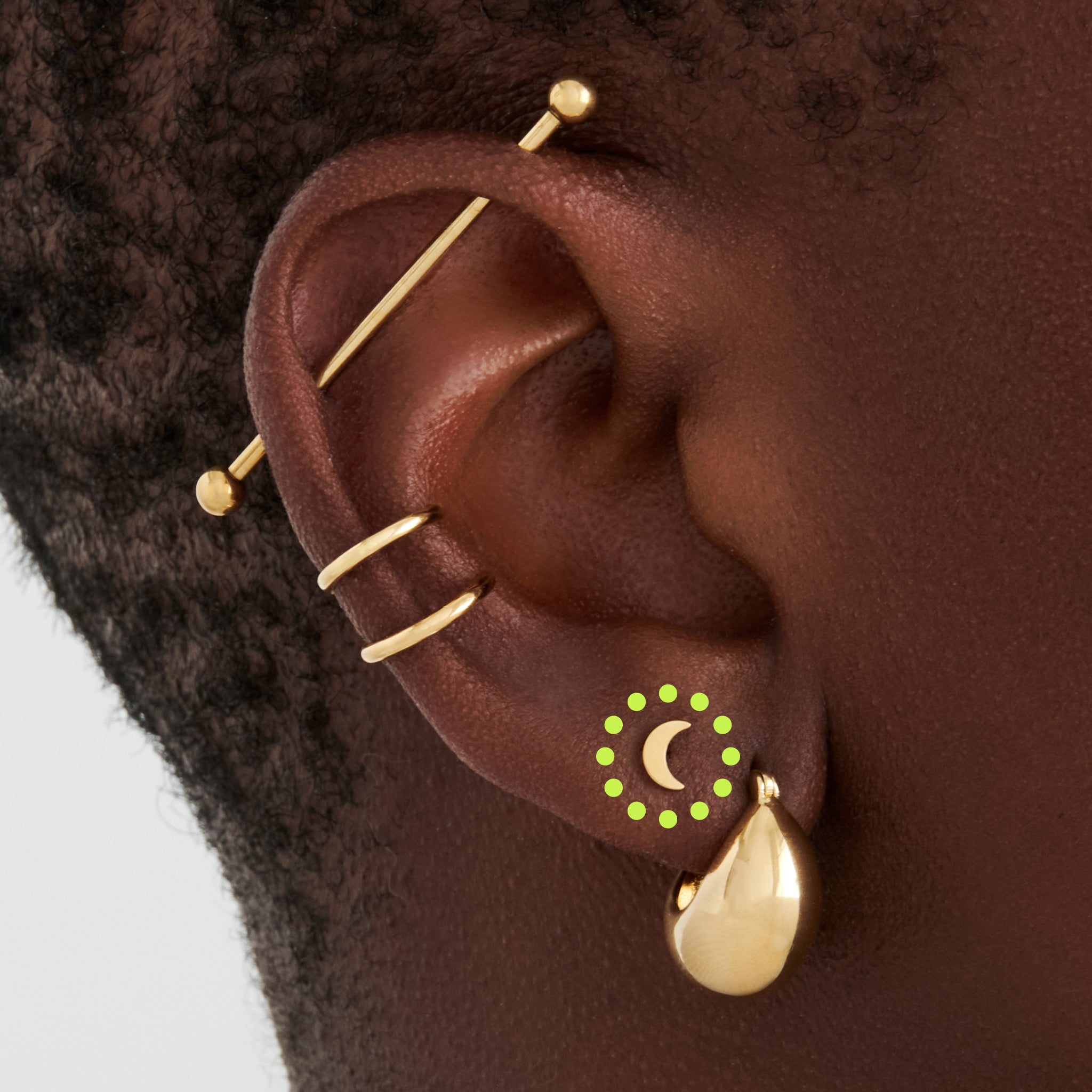 This is an image of a gold moon shaped flatback top with a gold labret with a circle disc with the "S" logo engraved in it. [hover] color:null|gold