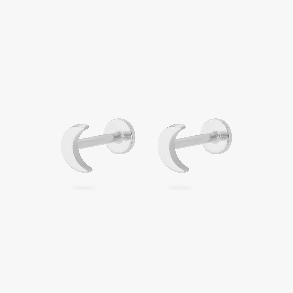 This is an image of a pair of silver moon shaped flatback tops with silver labrets with circle discs with the "S" logo engraved in them. [pair] color:null|silver/clear|silver