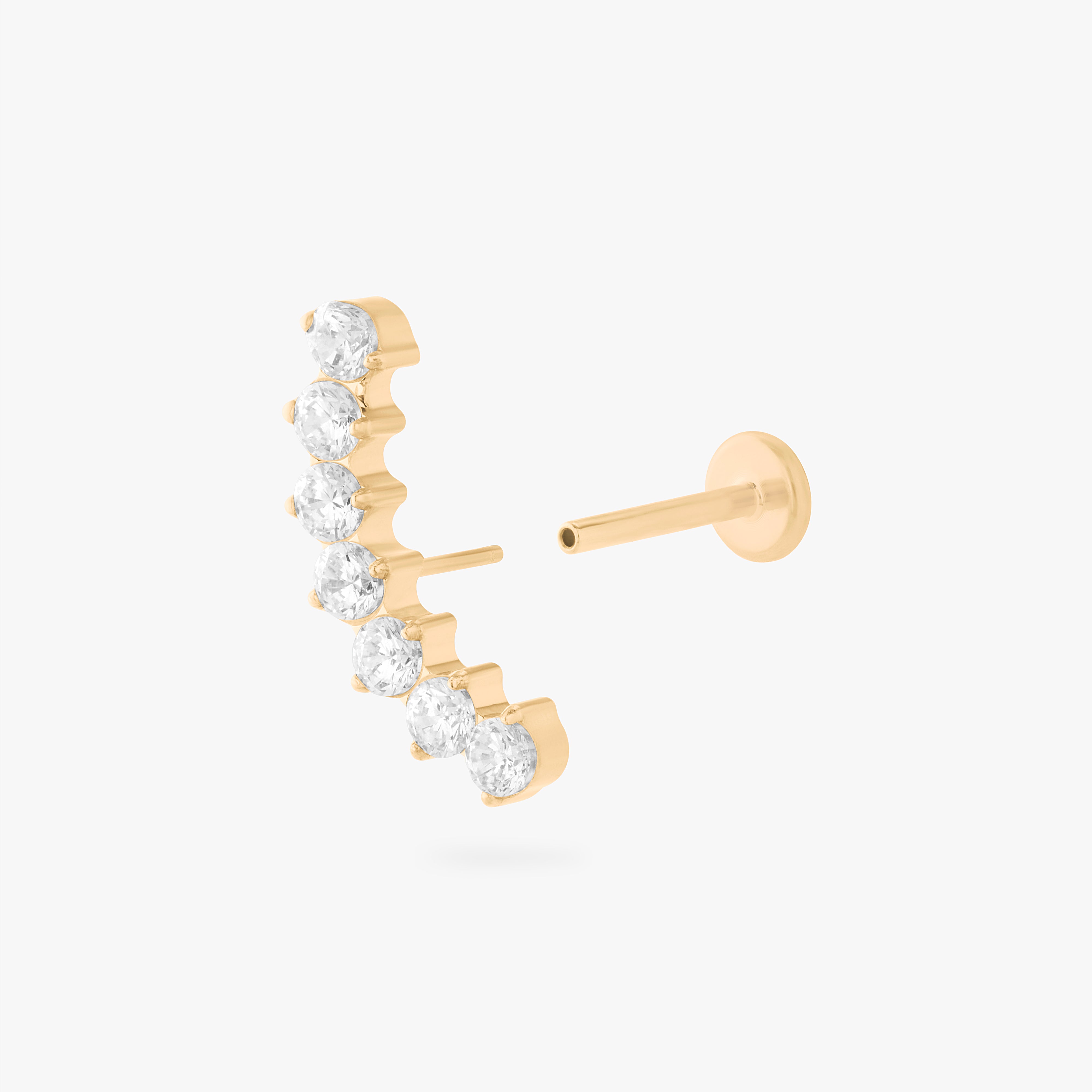 a flatback stud with a curved row of cz stones in gold color:null|gold/clear