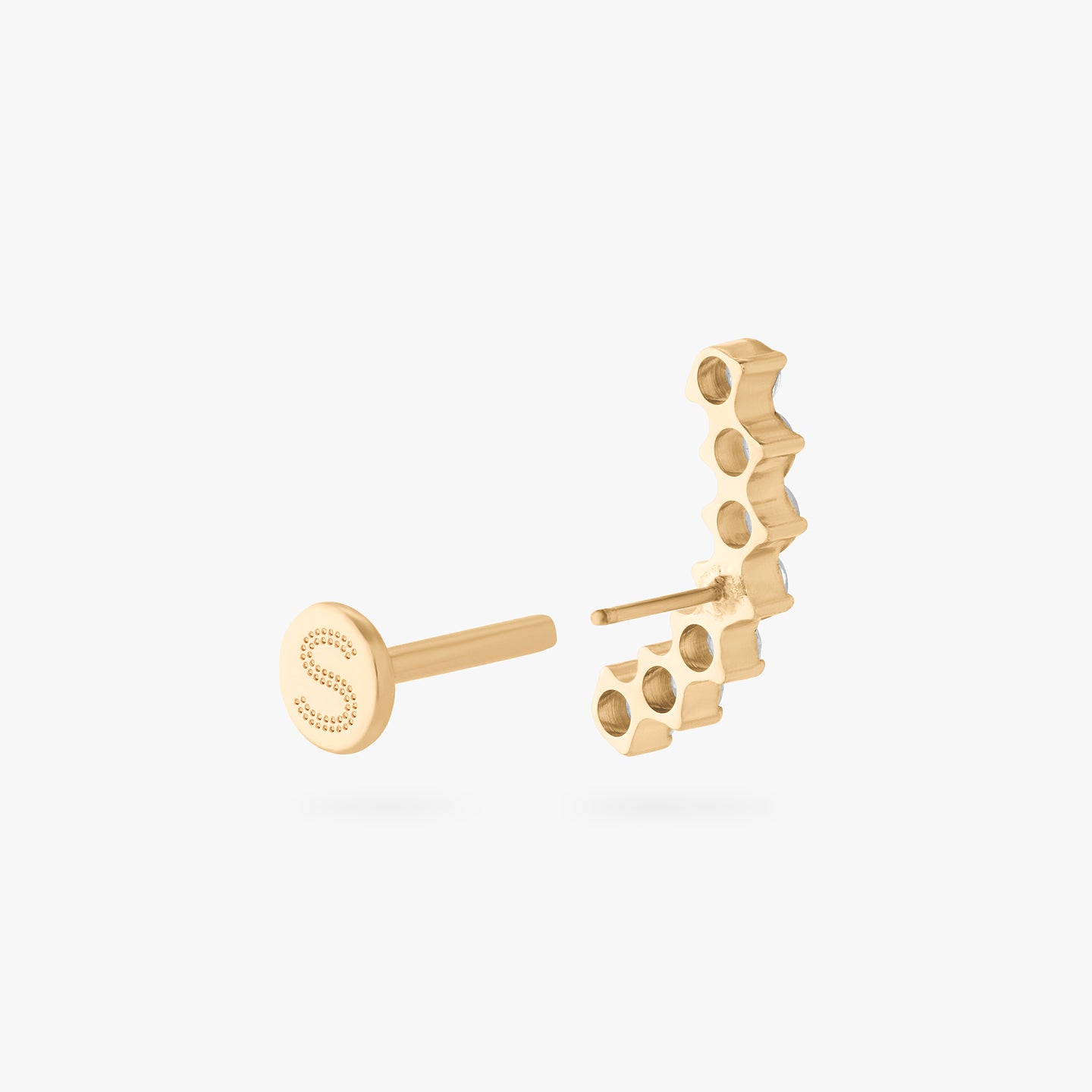 a flatback stud with a curved row of cz stones in gold color:null|gold/clear