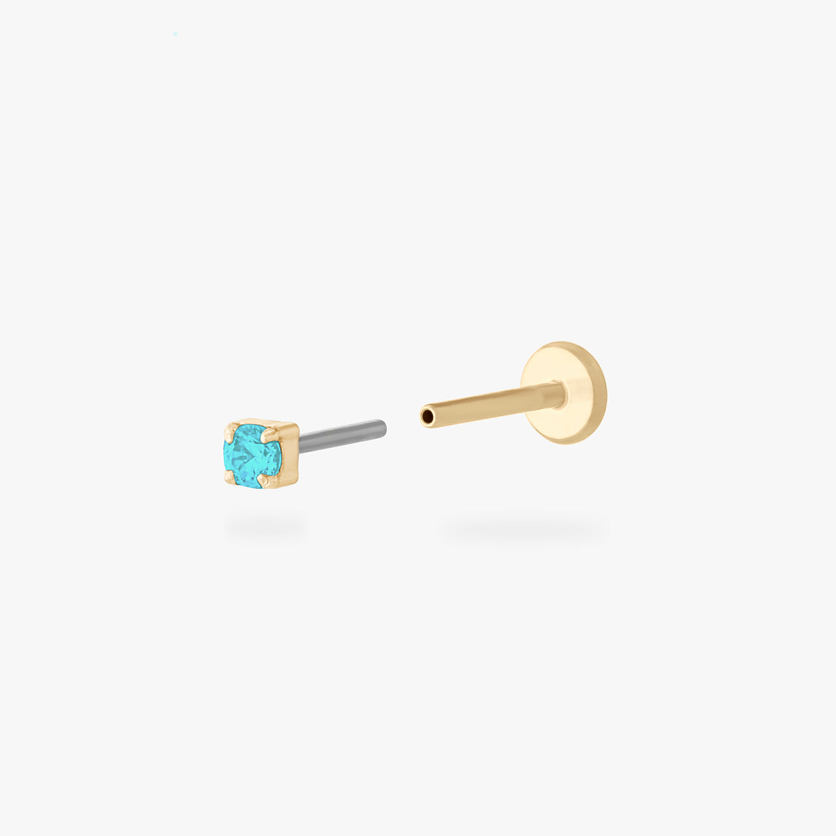 Gold stud flatback earring with a micro light blue cz gemstone on a white background