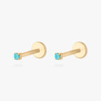 Pair of gold micro CZ flatback stud earrings with small light blue cz stones in prong setting displayed side by side