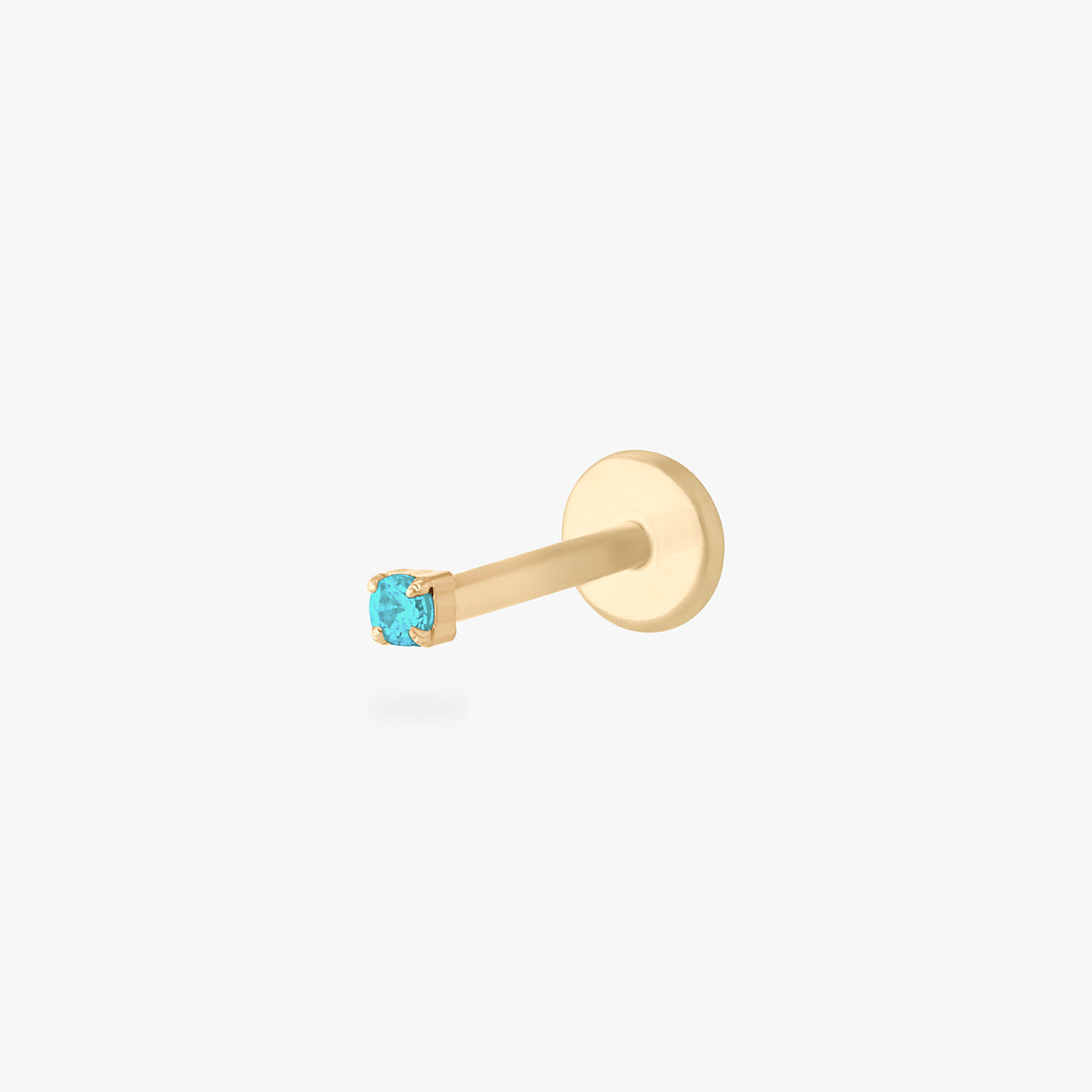 This is an image of a gold toned titanium flatback stud with a micro sized aquamarine CZ stone against a white background. 
