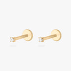 This is an image of a 14K yellow gold PVD plated titanium flatback stud with a clear CZ stone. This image displays a pair of the earrings.