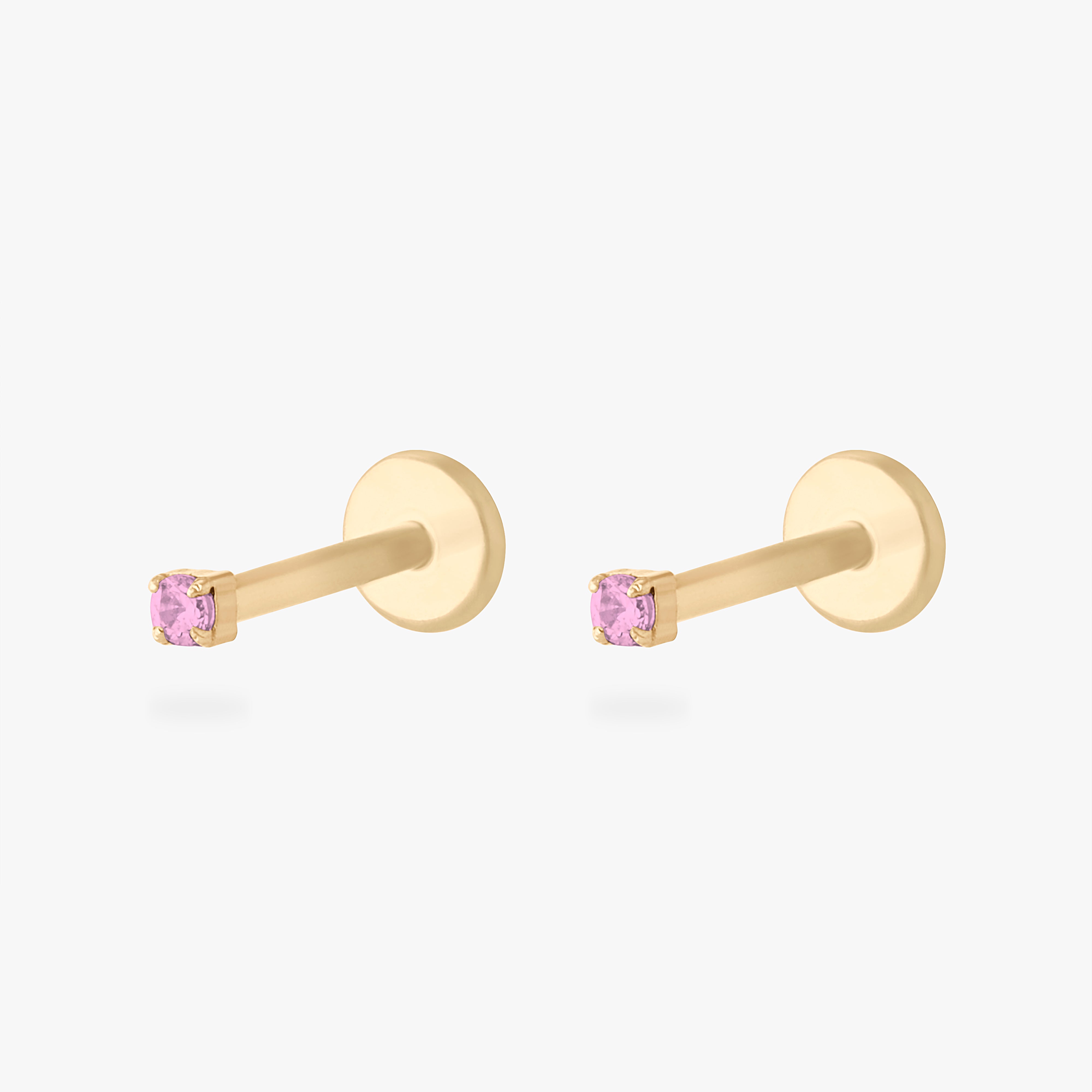 This is an image of a 14K yellow gold PVD plated titanium flatback stud with a pink CZ stone. This image displays a pair of the earrings. - Pair view