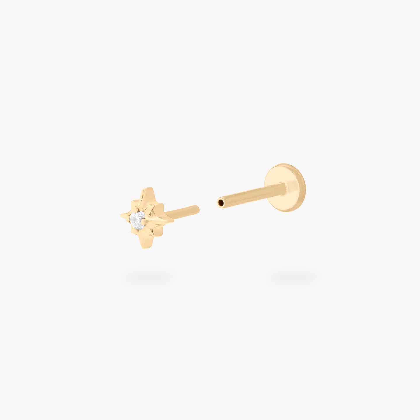 This is an image of a gold-toned flatback stud that is in the shape of a twinkle star with a clear CZ in the middle. color:null|gold/clear