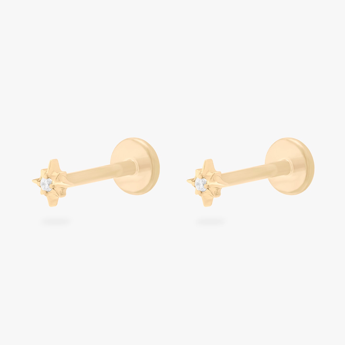 This is an image of a pair of gold-toned flatback studs that are in the shape of a twinkle star with clear CZ's in the middle. [pair] color:null|gold/clear