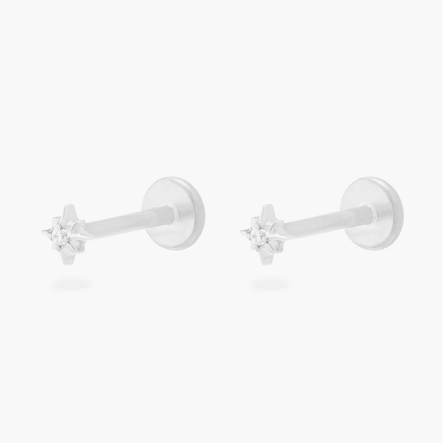 This is an image of a pair of silver-toned flatback studs that are in the shape of twinkle stars with clear CZ's in the middle. [pair] color:null|silver/clear