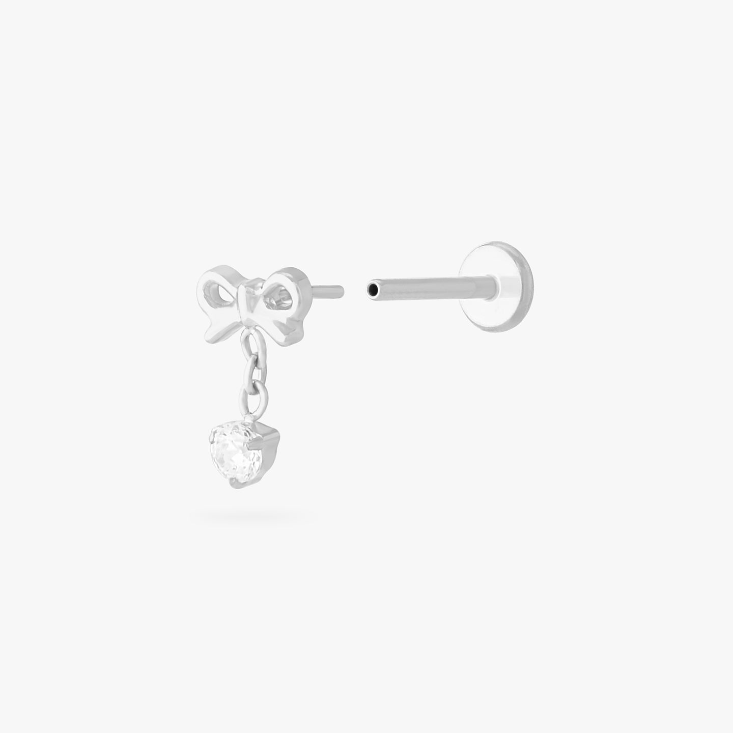 This is an image of a silver-toned flatback stud with a bow that a chain with a CZ dangles from. color:null|silver/clear