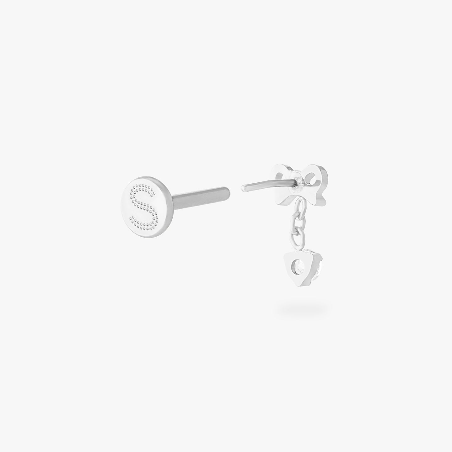 This is an image of a silver-toned flatback stud with a bow that a chain with a CZ dangles from. color:null|silver/clear