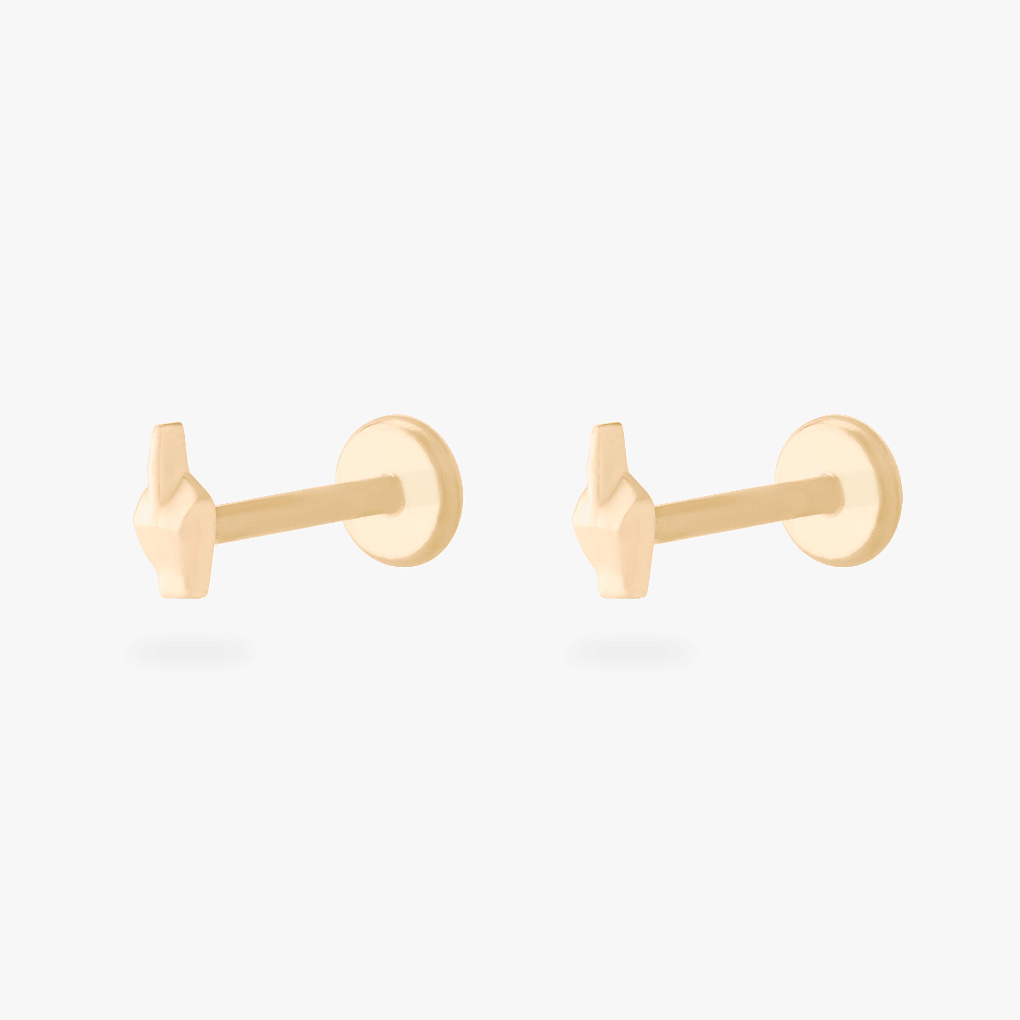 This is an image of a pair of gold-toned flatback studs that are in the shape of middle fingers. [pair] color:null|gold