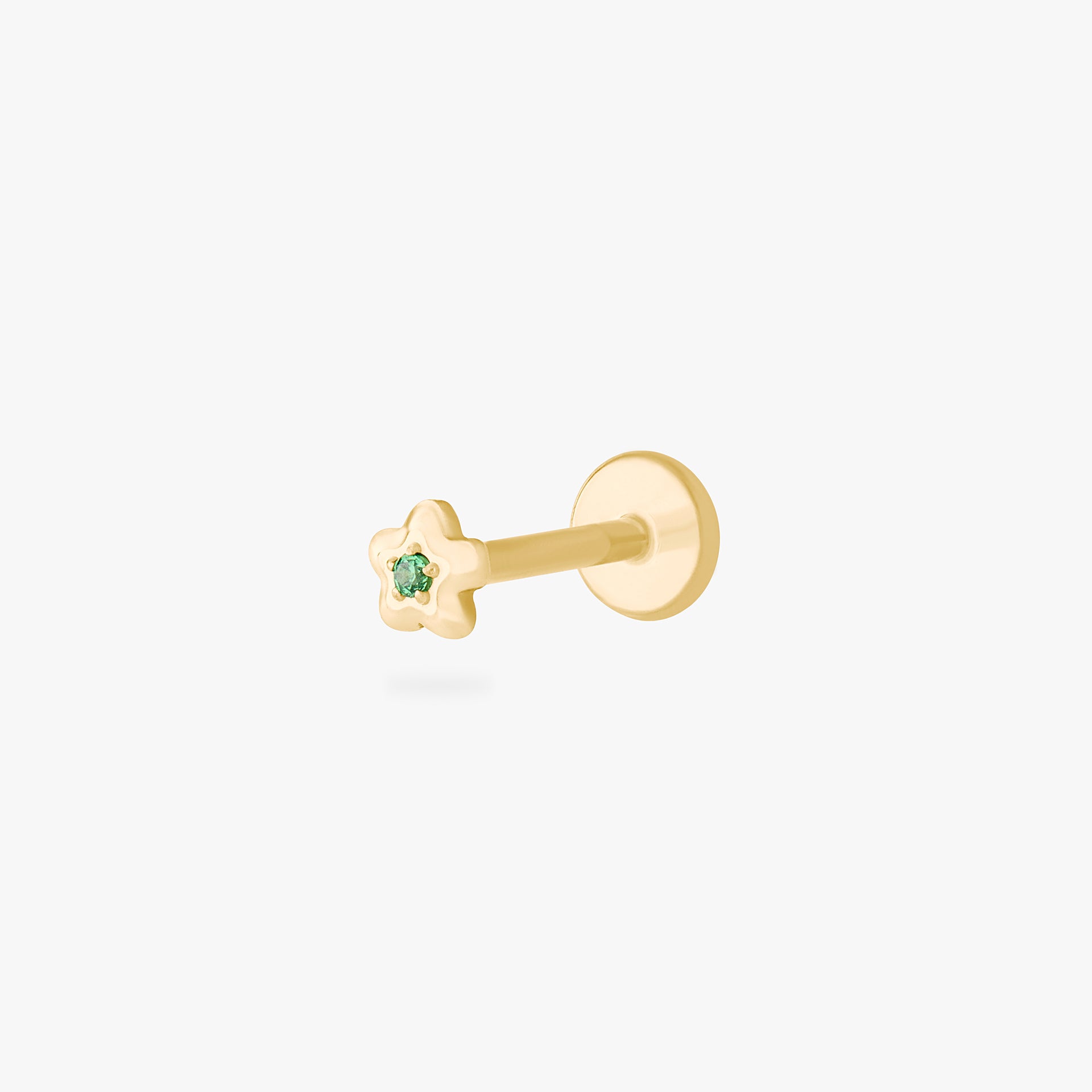 This is an image of a gold toned flatback stud that is shaped like a flower with a green cz in the center. color:null|gold/green