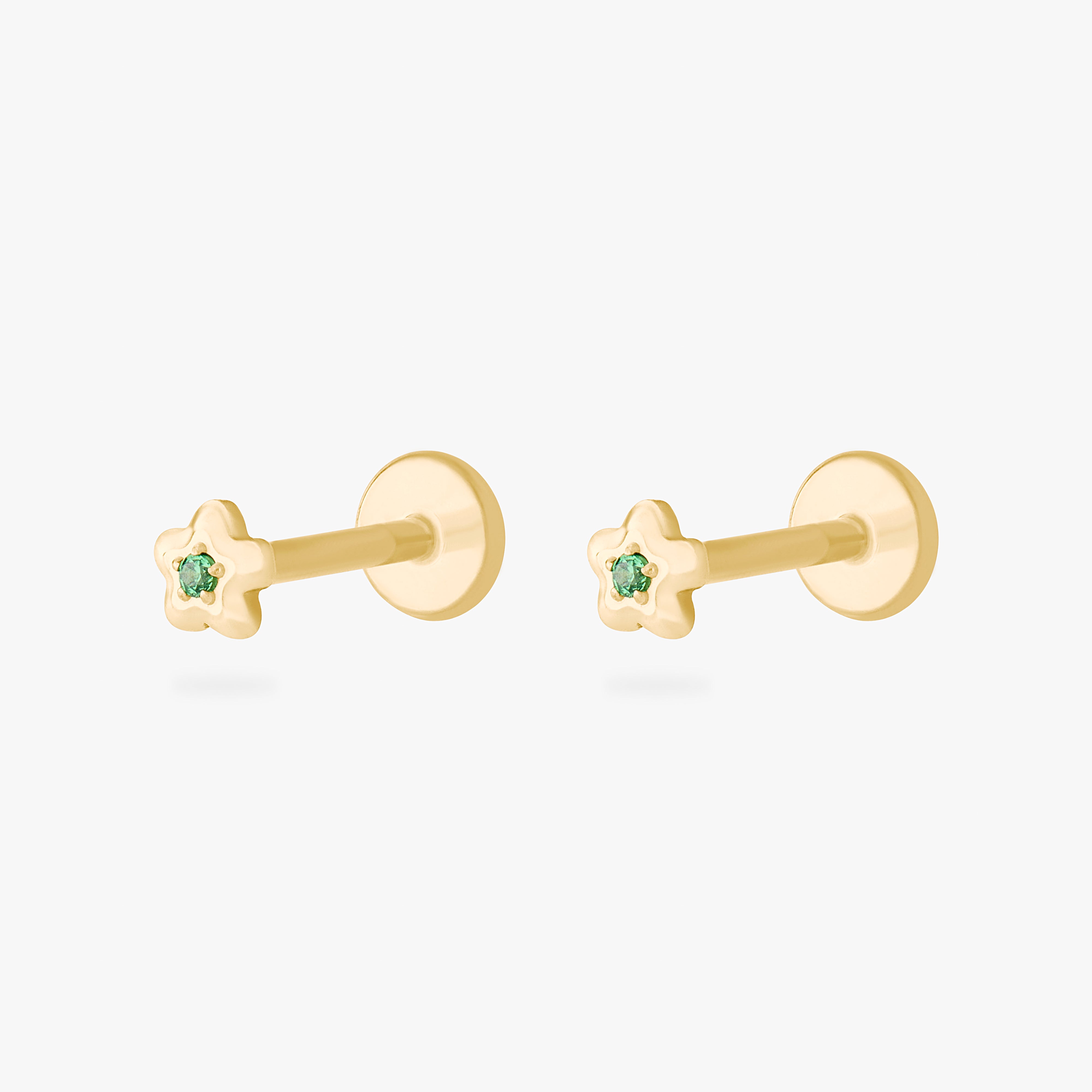 This is an image of a pair of gold toned flatback studs that are shaped like flowers with green cz's in the center. [pair] color:null|gold/green