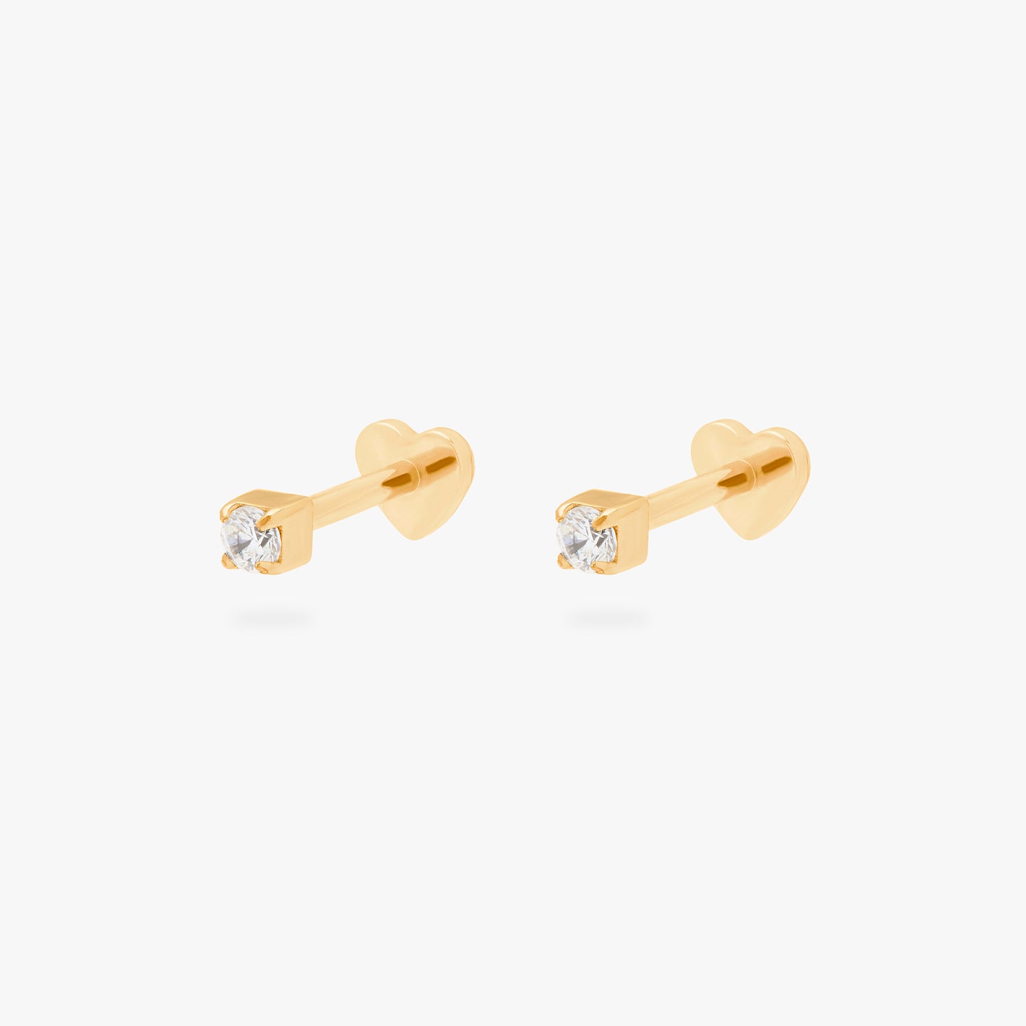 This is an image of a pair of gold/clear mini CZ flatback tops, with gold labrets with heart-shaped discs. [pair] color:null|gold/clear
