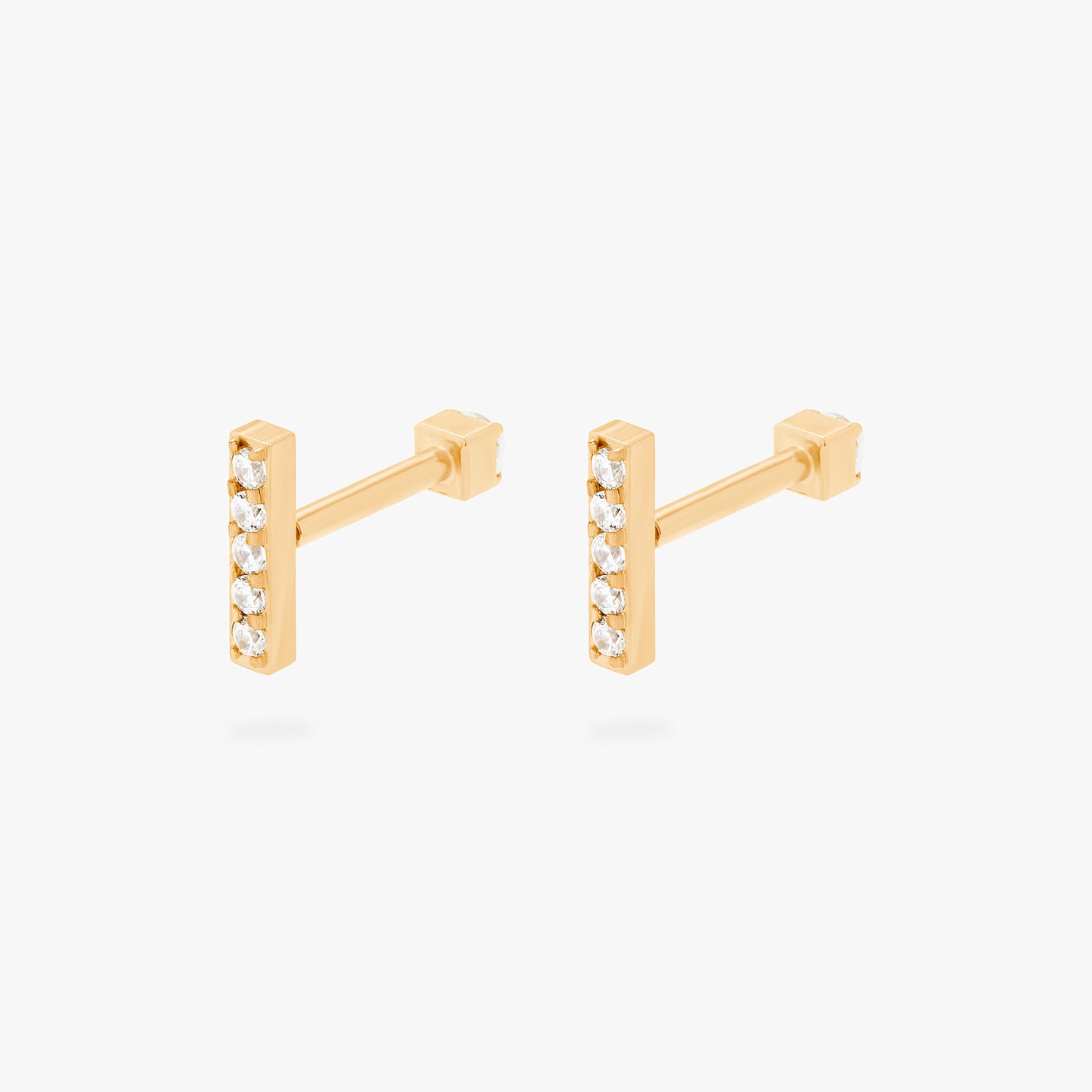 This is an image of a gold/clear bar that has 5 mini CZs in a line formation with a gold/clear CZ flatback post [pair] color:null|gold/clear