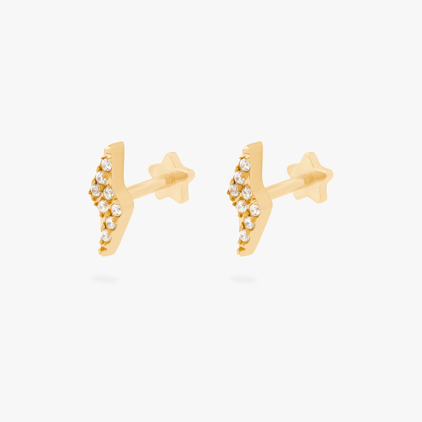 This is an image of a pair of gold/clear pave lightning-bolt shaped flatback tops with gold labrets that have star-shaped discs. [pair] color:null|gold/clear