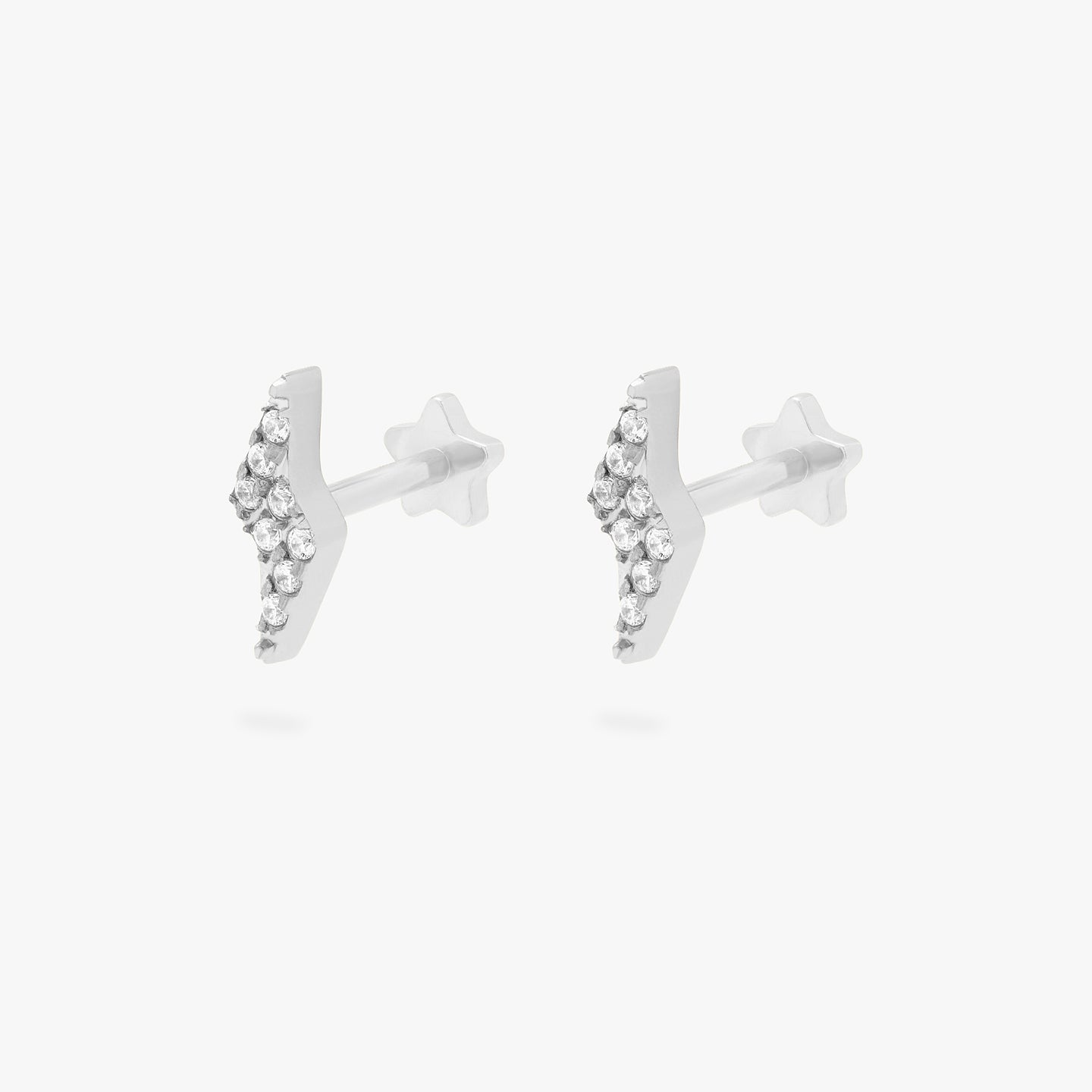 This is an image of a pair of silver/clear pave lightning-bolt shaped flatback tops with silver labrets that have star-shaped discs. [pair] color:null|silver/clear