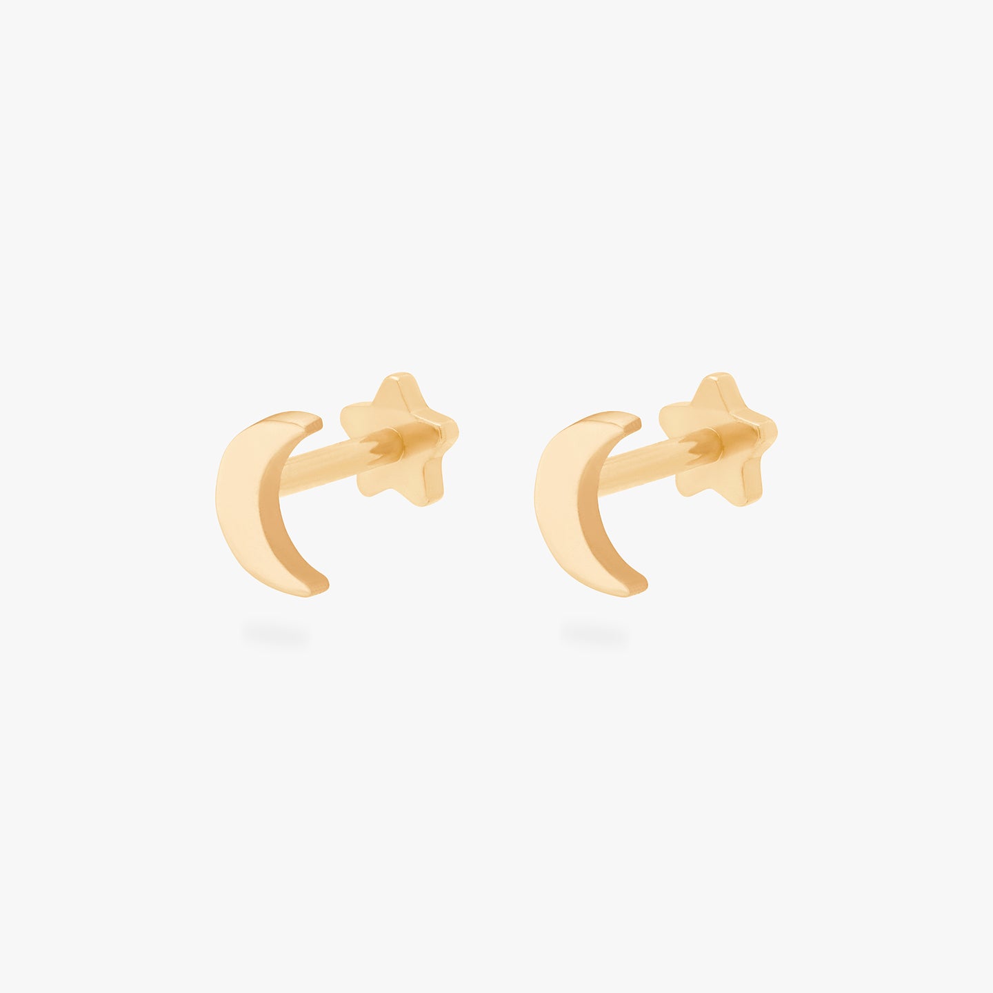 This is an image of a pair of gold moon-shaped flatback tops with gold labrets with star-shaped discs. [pair] color:null|gold