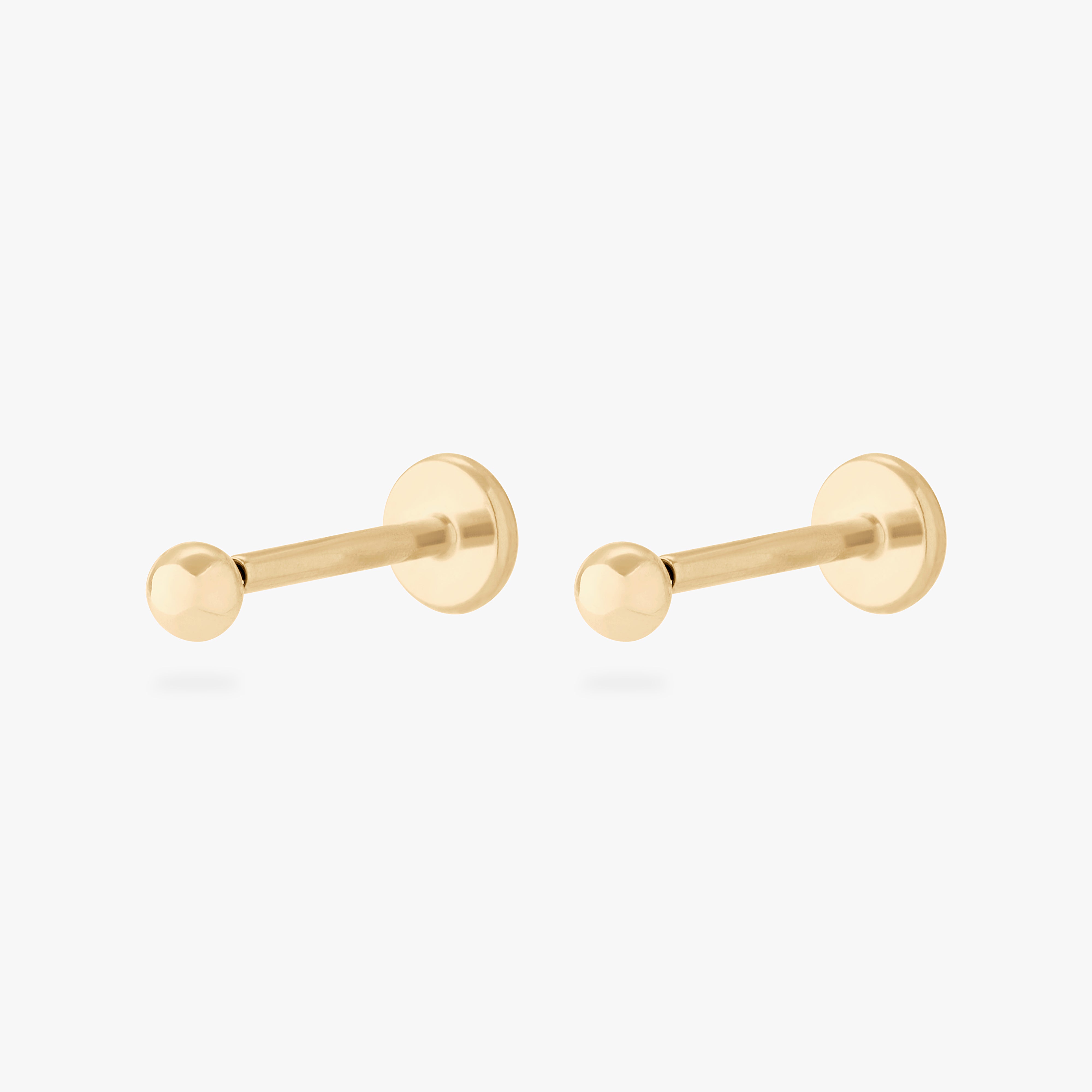 This is an image of a pair of 14k gold flatback studs that are shaped like solid golden balls. [pair] color:null|14k gold
