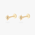 This is an image of a pair of 14K gold flatback studs with pointed stars with clear cz stones in the center. [pair] color:null|gold|gold/clear