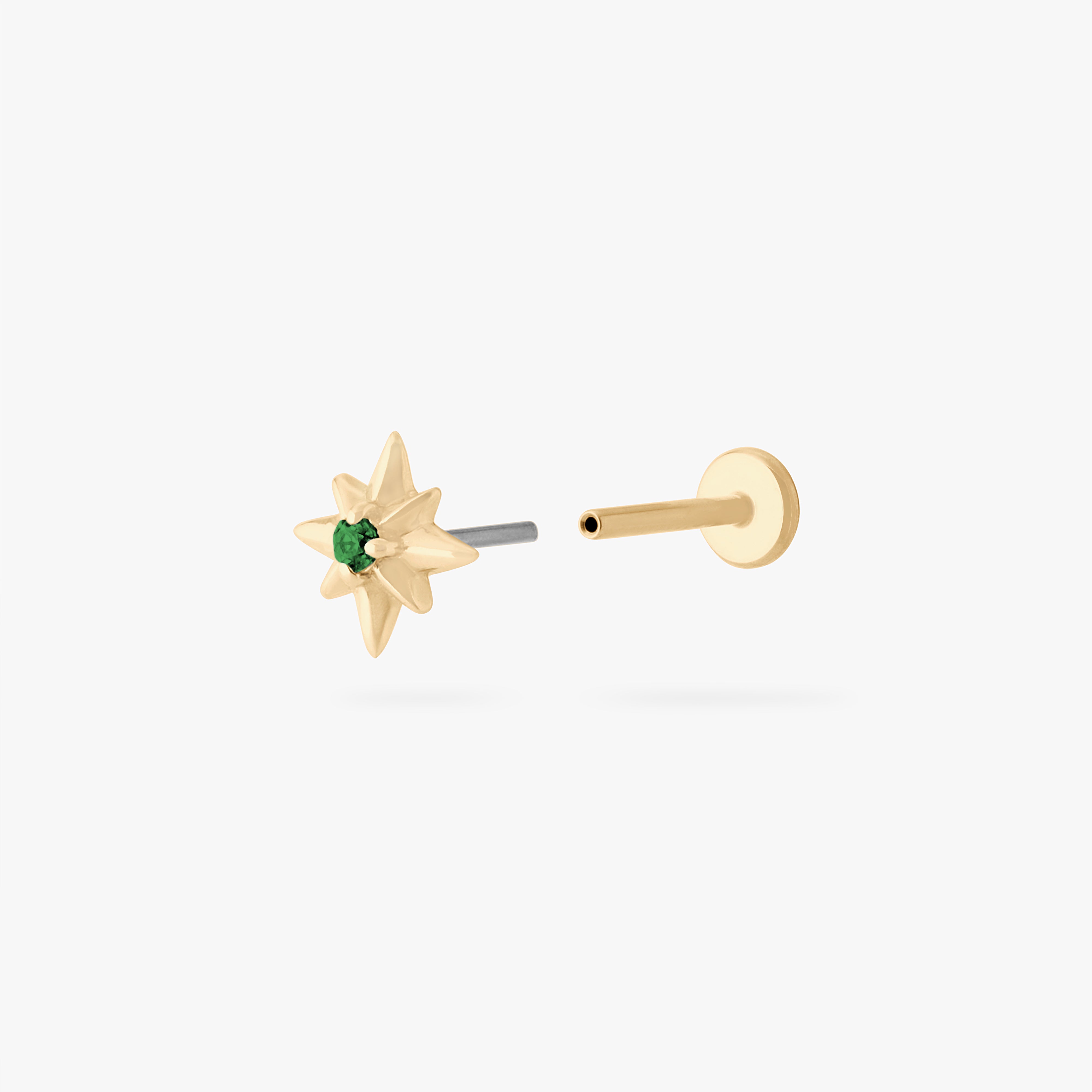 This is an image of a 14K gold flatback stud with a pointed star with a green cz stone in the center. color:null|gold/green