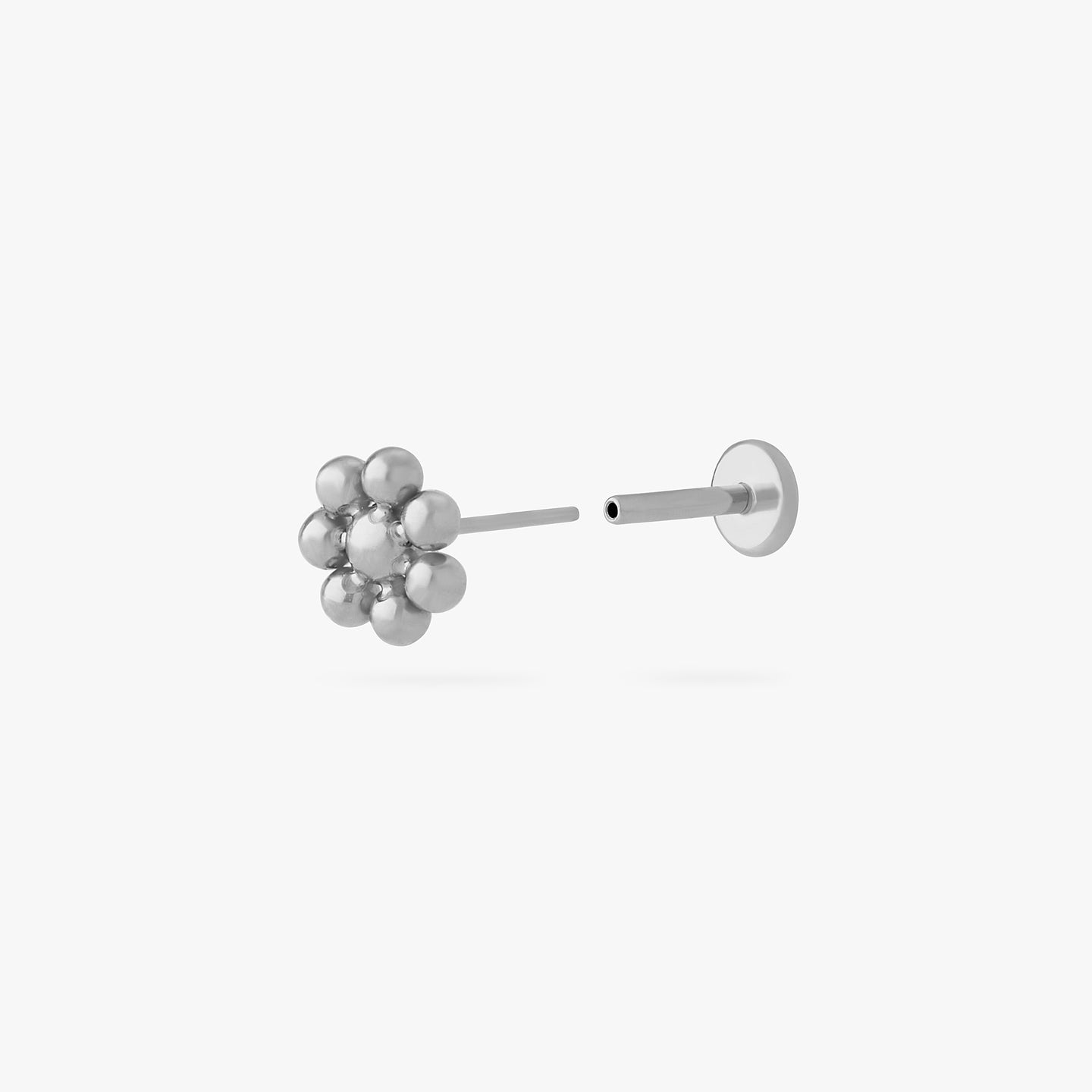 a small flower-shaped titanium flatback stud color:null|titanium