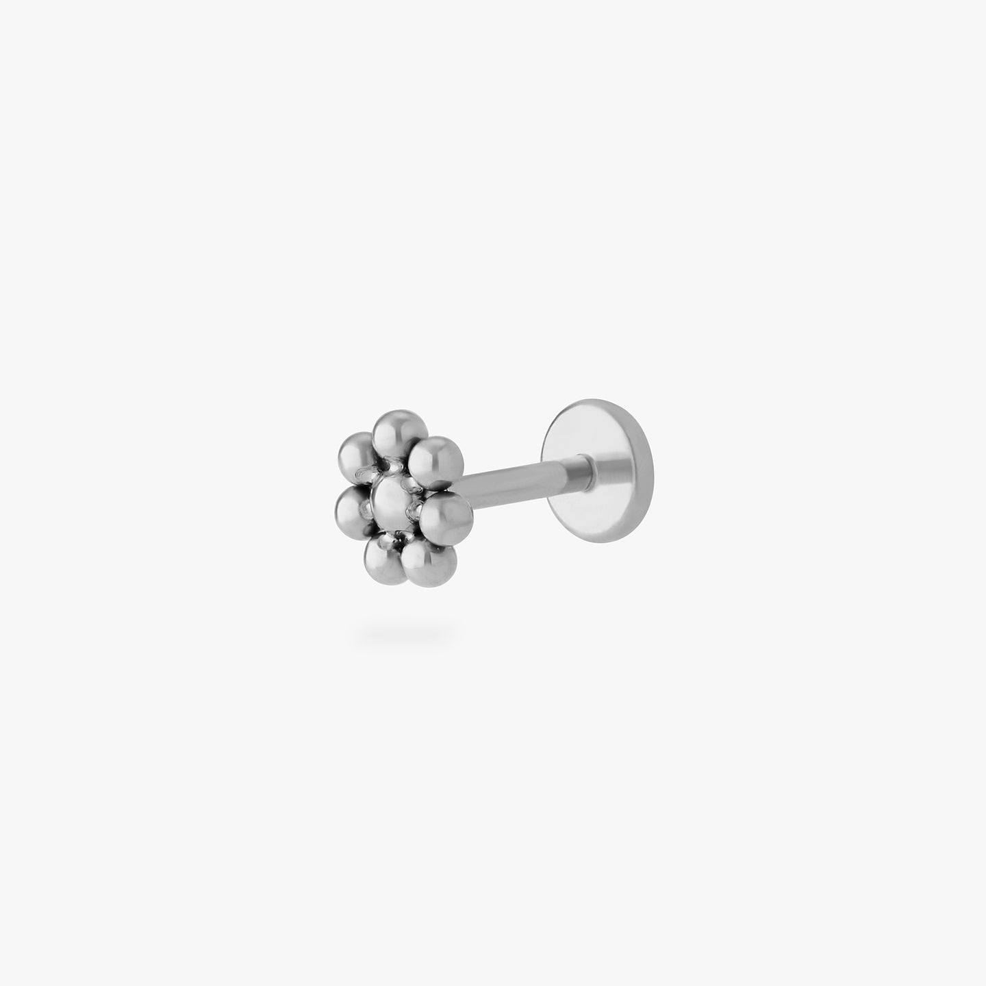 a small flower-shaped titanium flatback stud color:null|titanium