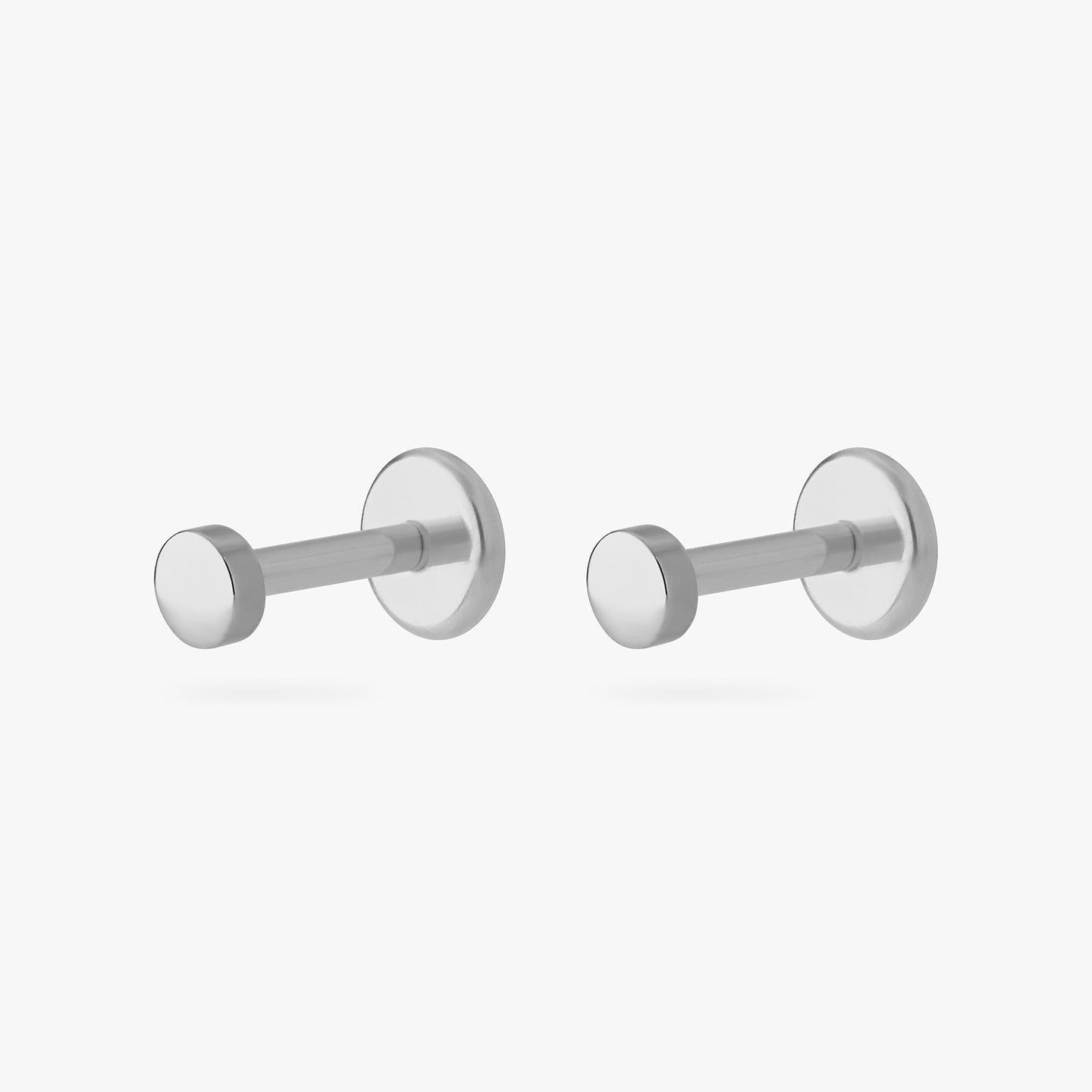 a small stud in the shape of a flat-topped circle made of titanium [pair] color:null|titanium