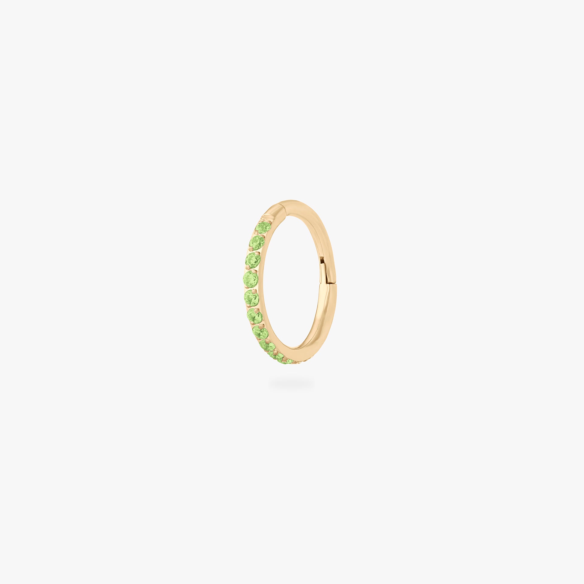 This is an image of a gold toned titanium clicker with an 8mm diameter and peridot cz stones in a pave setting. - Main view