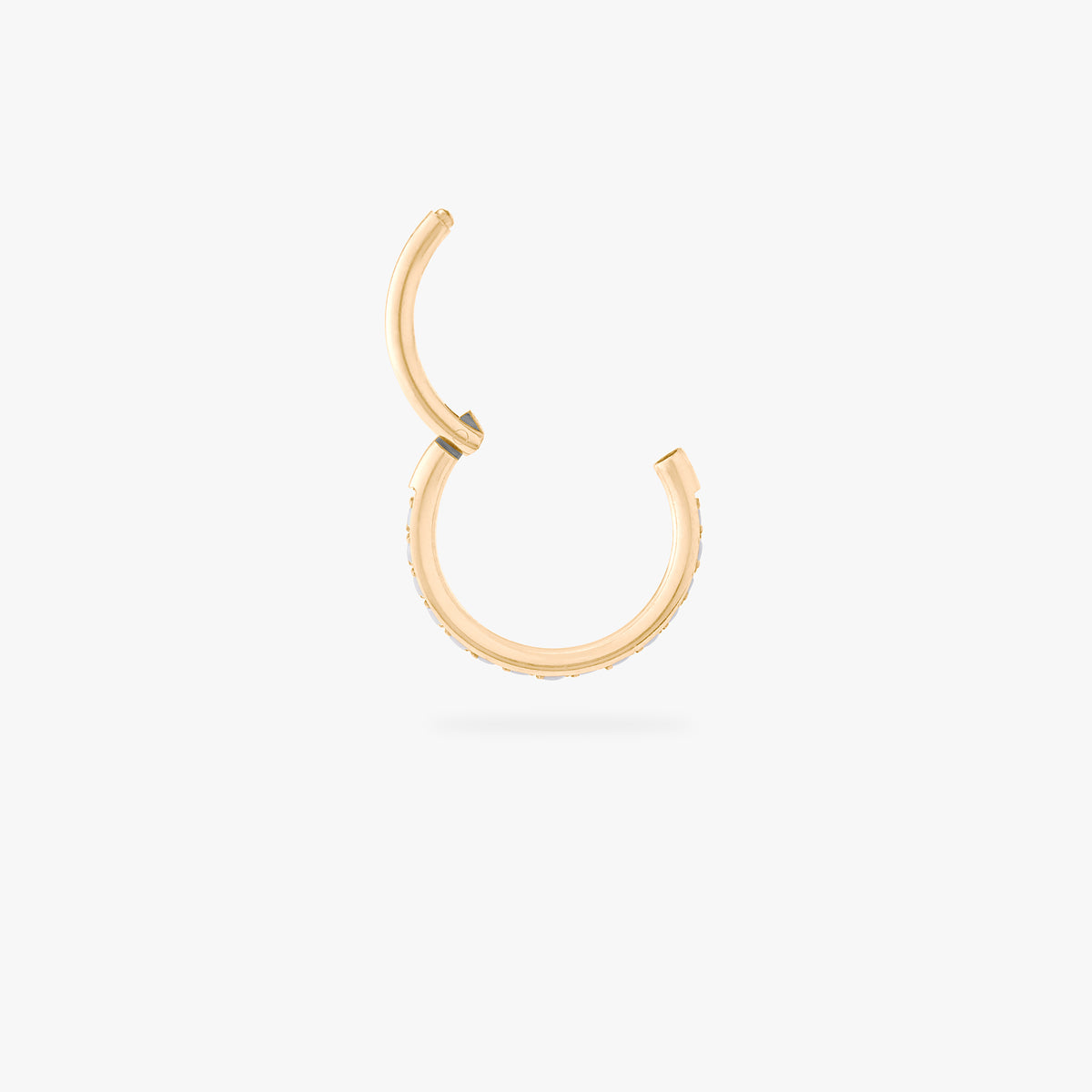 This is an image of a gold-toned titanium clicker with pearl cz stones. color:null|pearl