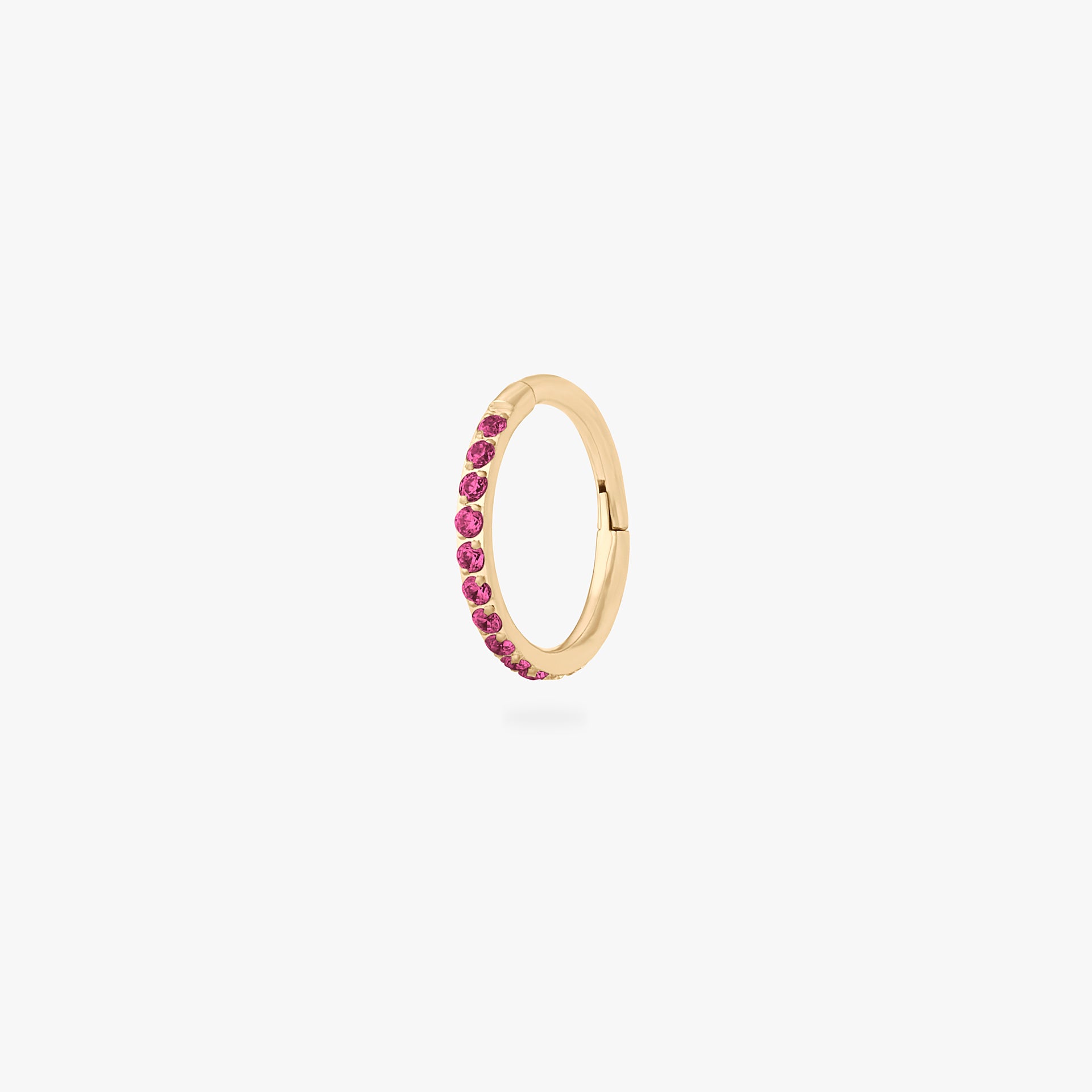 This is an image of a gold toned titanium clicker with an 8mm diameter and ruby cz stones in a pave setting. - Main view