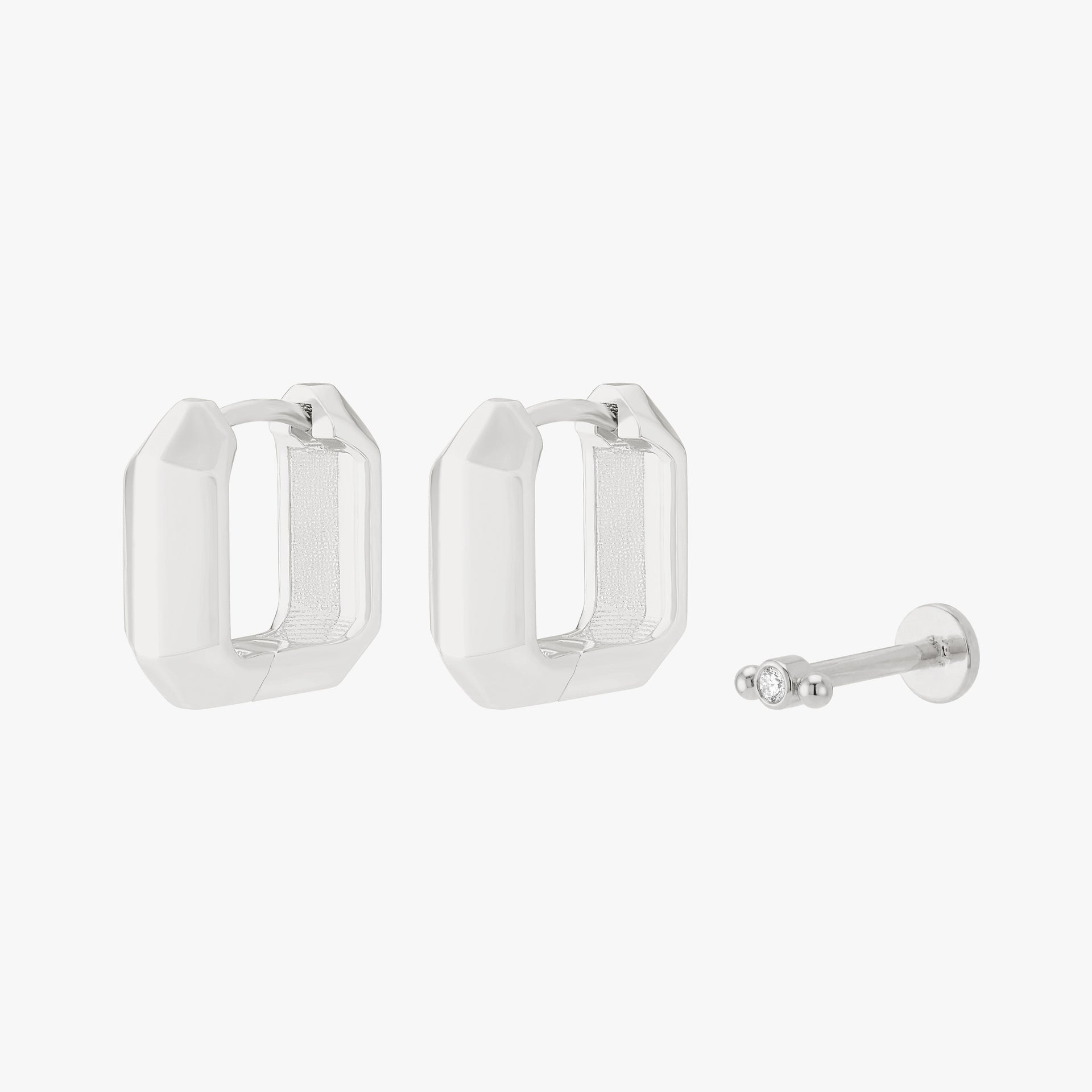 Silver earscape set with a pair of geometric huggies and a micro bezel flatback with a clear stone - Main view