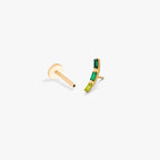 This image shows the side view of a golden titanium baguette flatback with three green cz stones separated from labret
